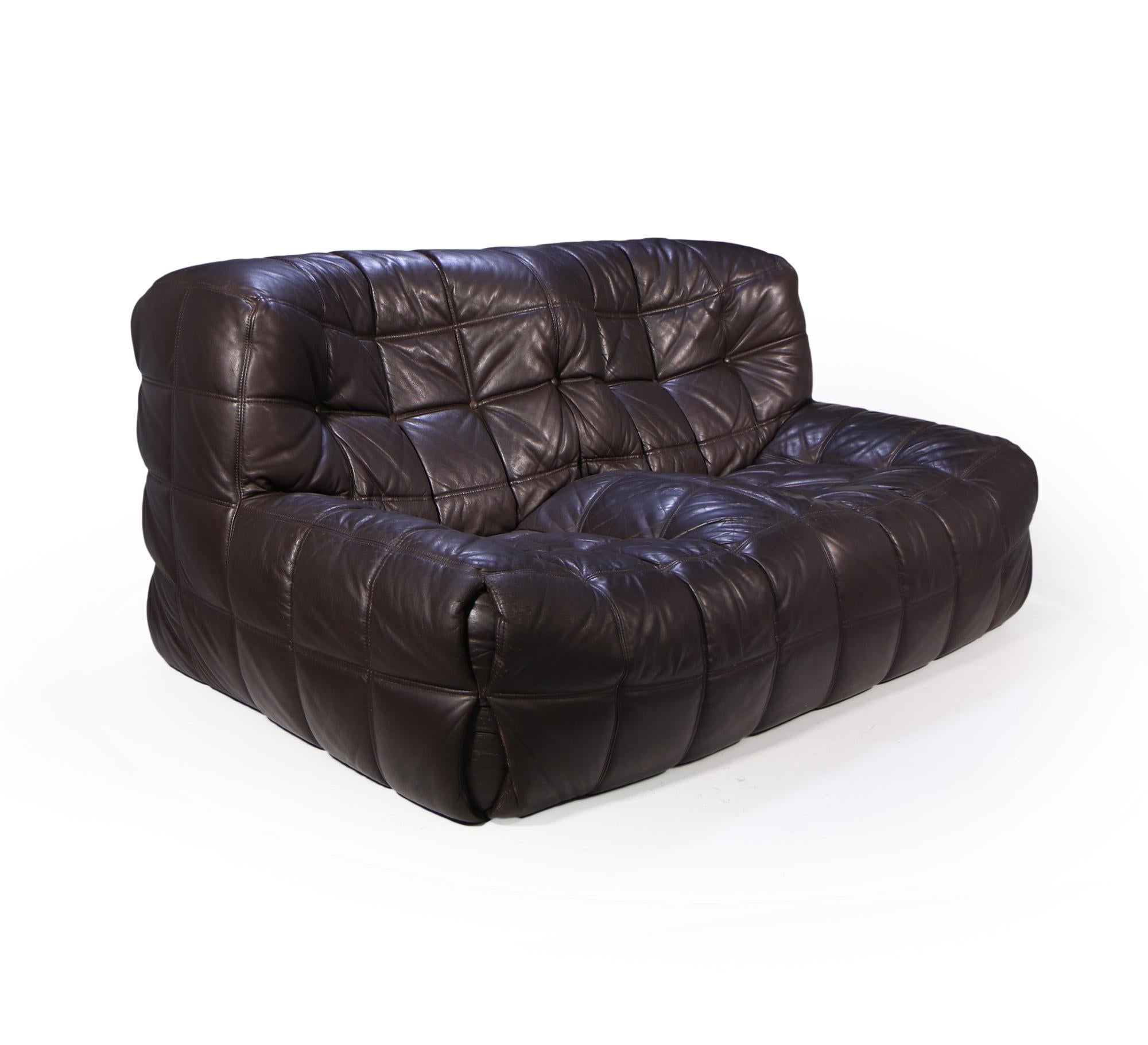 A two seat brown leather sofa Michel Ducaroy for Ligne Roset the Kashima is understated but outstanding design and comfortable, the sofa is low to the ground with moulded seats using different levels of foam leaving two shaped seating areas. This
