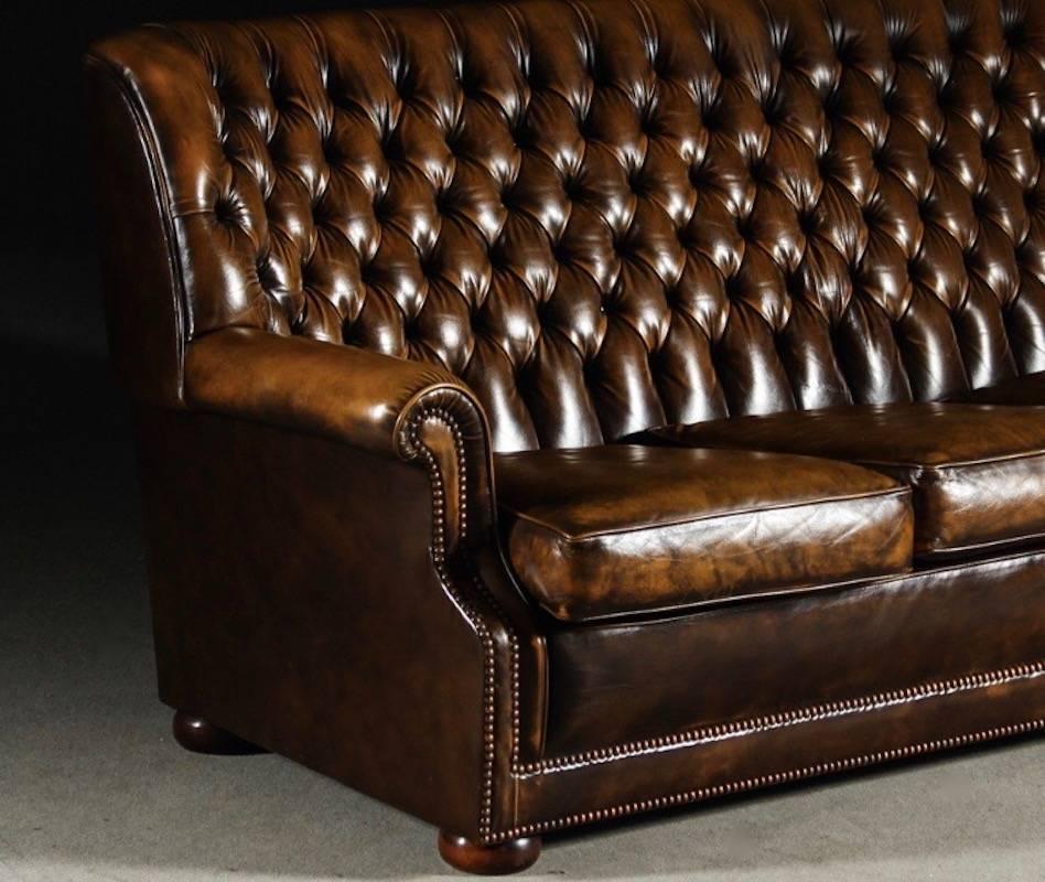 Brown leather Chesterfield sofa with high back from circa 20th century second half, made in England. Labelled Pegasus, Art Forma Upholstery Ltd, model Cleveland. Button-tufted leather upholstery, round wooden feet. Very comfortable to sit on.