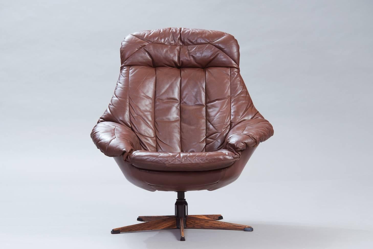 Swivel lounge chair “Silhouette” model in brown leather.