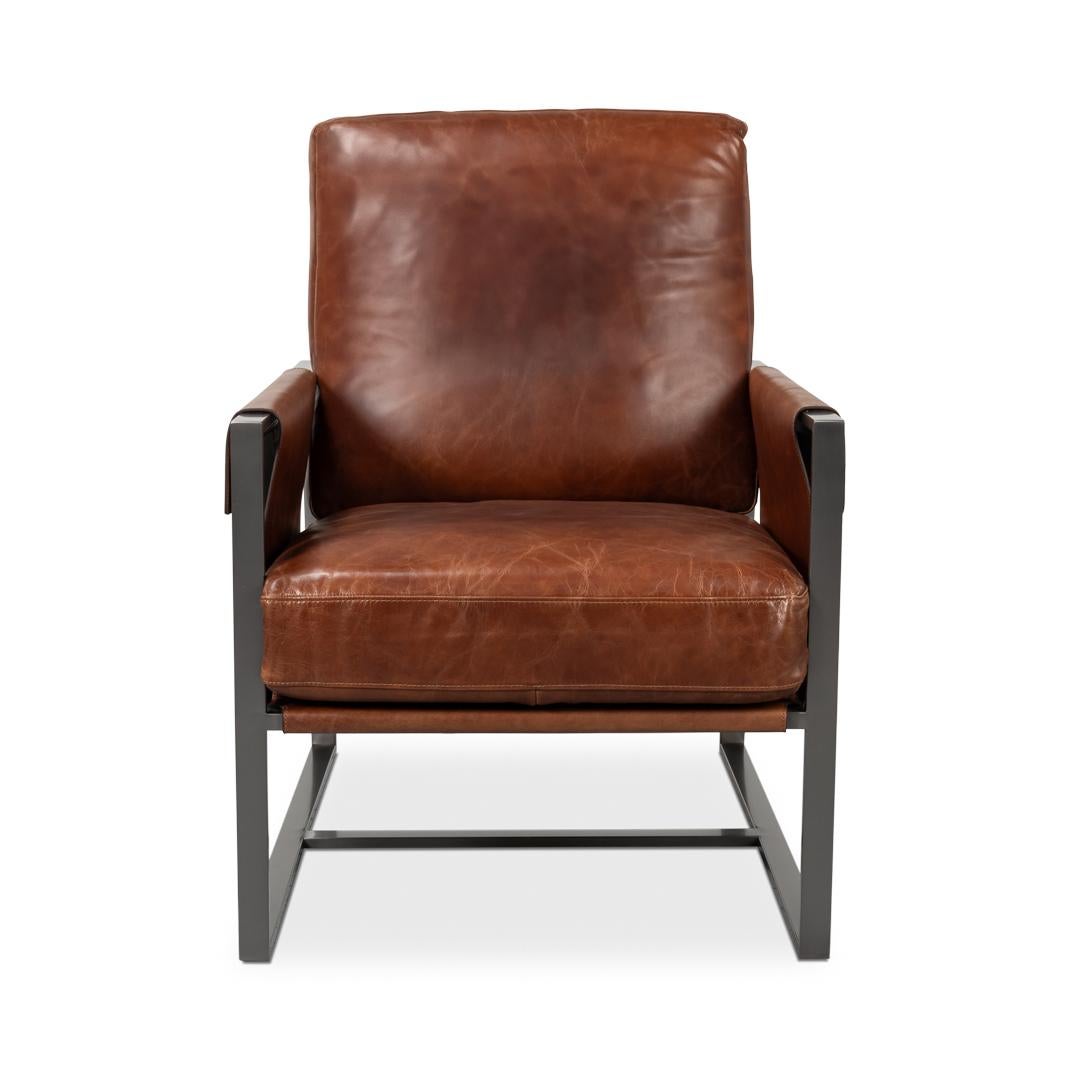 Revêtue d'un riche cuir brun Newark, cette chaise est dotée d'un cadre en métal industriel pour une esthétique contemporaine. Les accoudoirs en bandoulière uniques sont complétés par des boucles latérales en cuir, ajoutant à la fois du caractère et