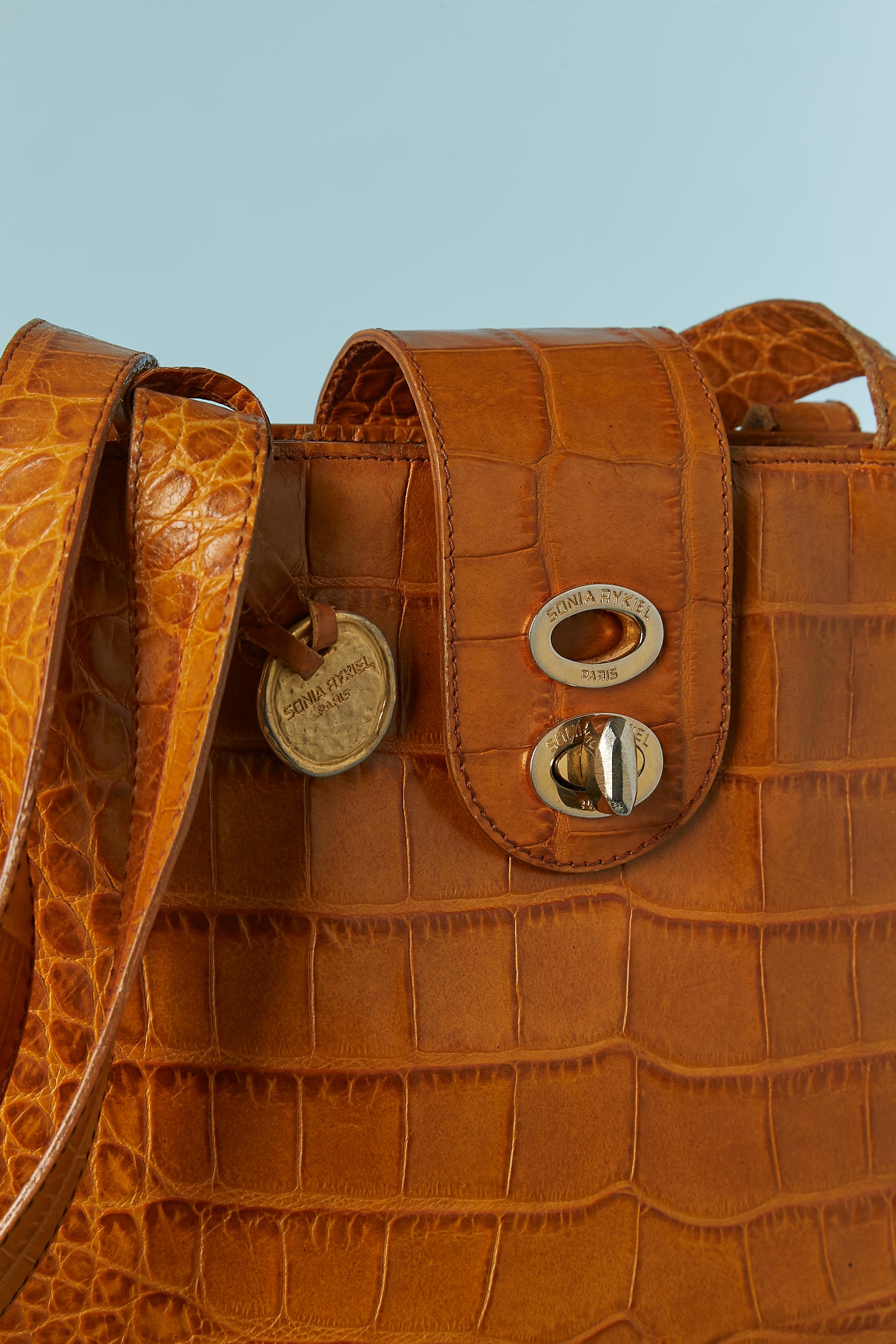 Brown leather structured shoulder bag with crocodile pattern. Branded nylon lining. Zip closure on the middle top. One inside pocket with zip. Studs underneath. Snap on both side.
SIZE 34CM X 24CM X 10CM 
Shoulder straps lenght : 73 cm 
