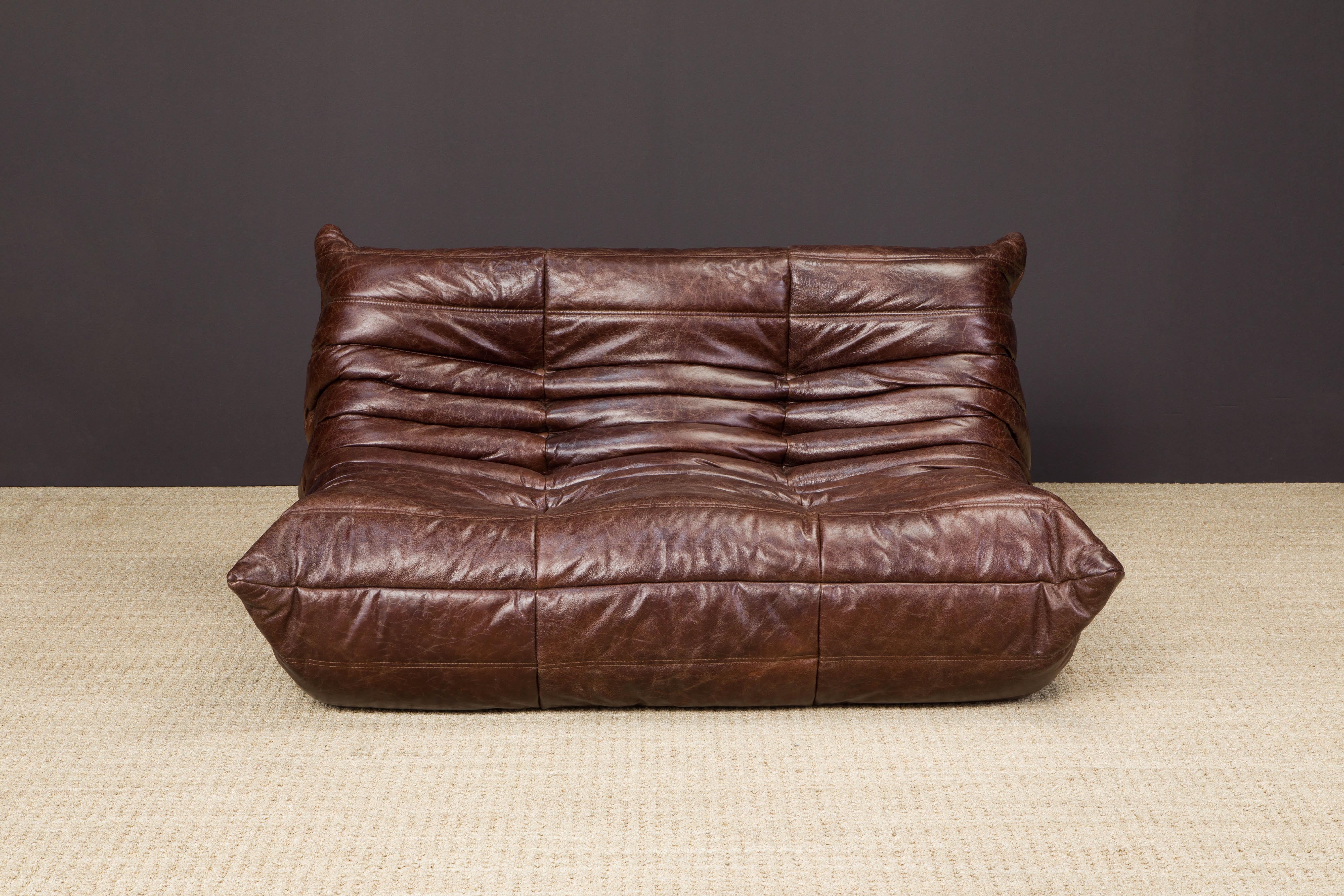 This gorgeous deep brown leather 'Togo' loveseat sofa was designed by Michel Ducaroy in 1973 for Ligne Roset, France. Signed with Ligne Roset Made in France label and has Ligne Roset fabric underneath. 

Timeless design and classic style make this