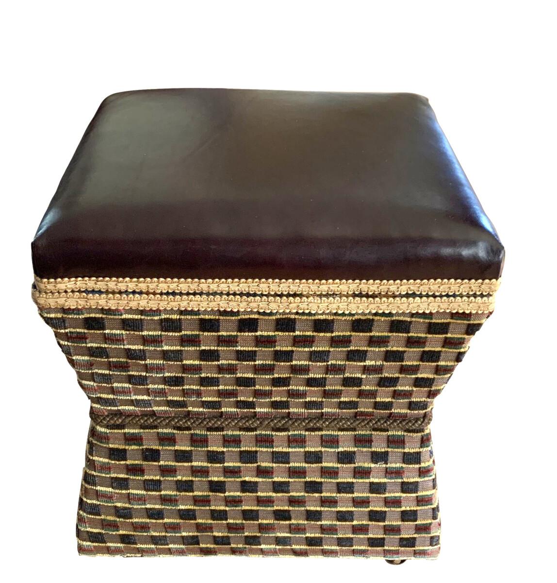 19th century English leather top foot stool.
The leather top is brown, square patterned upholstery on the sides.
The hour glass shaped stool is on casters for easy movement.
The top lifts up for storage, revealing floral print upholstery.
 