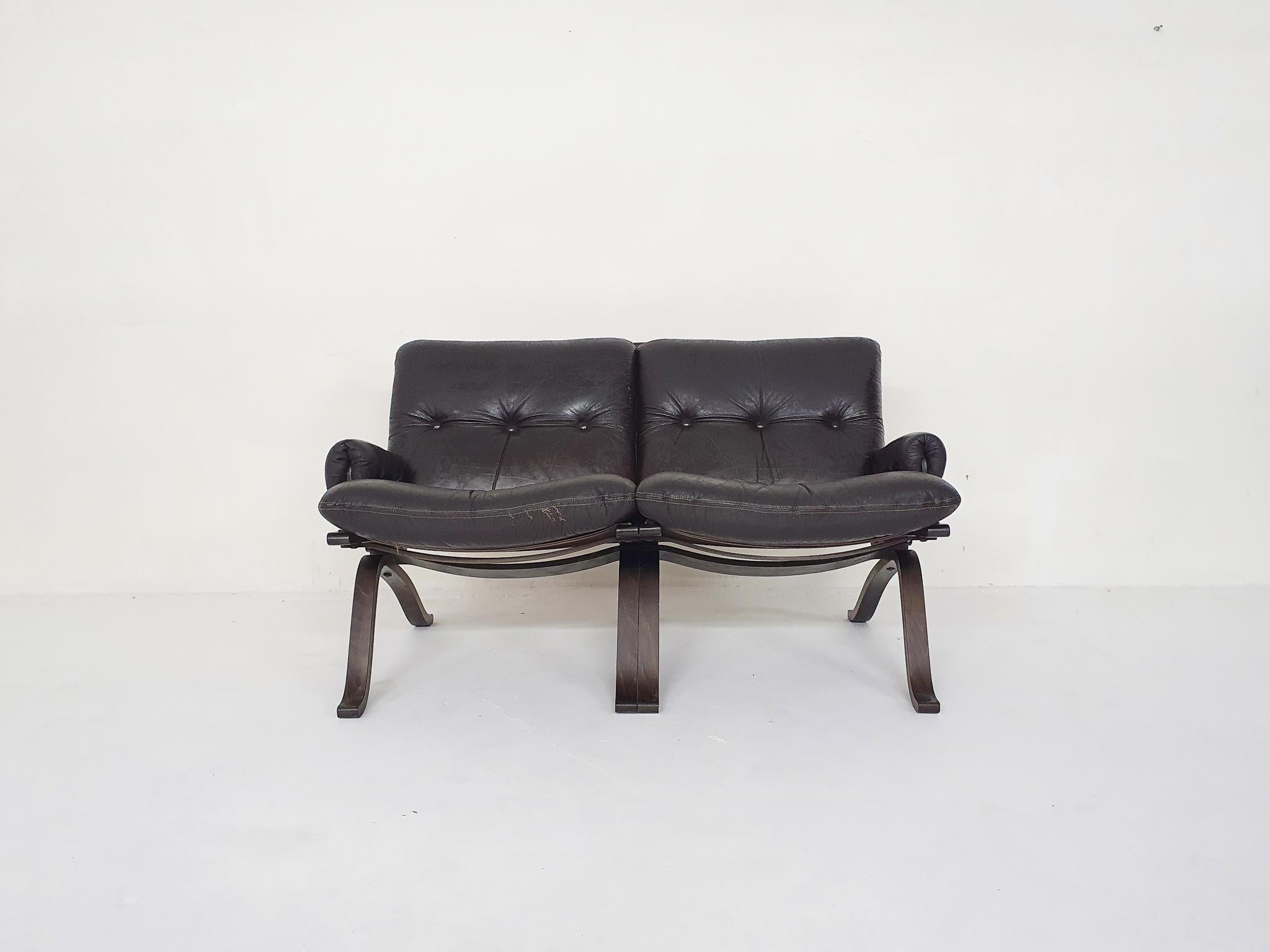 Plywood two-seater sofa with dark brown leather cushions. Some traces of use, on the front of the seating cushion.
Attributed to Ingmar Relling for Westnofa.