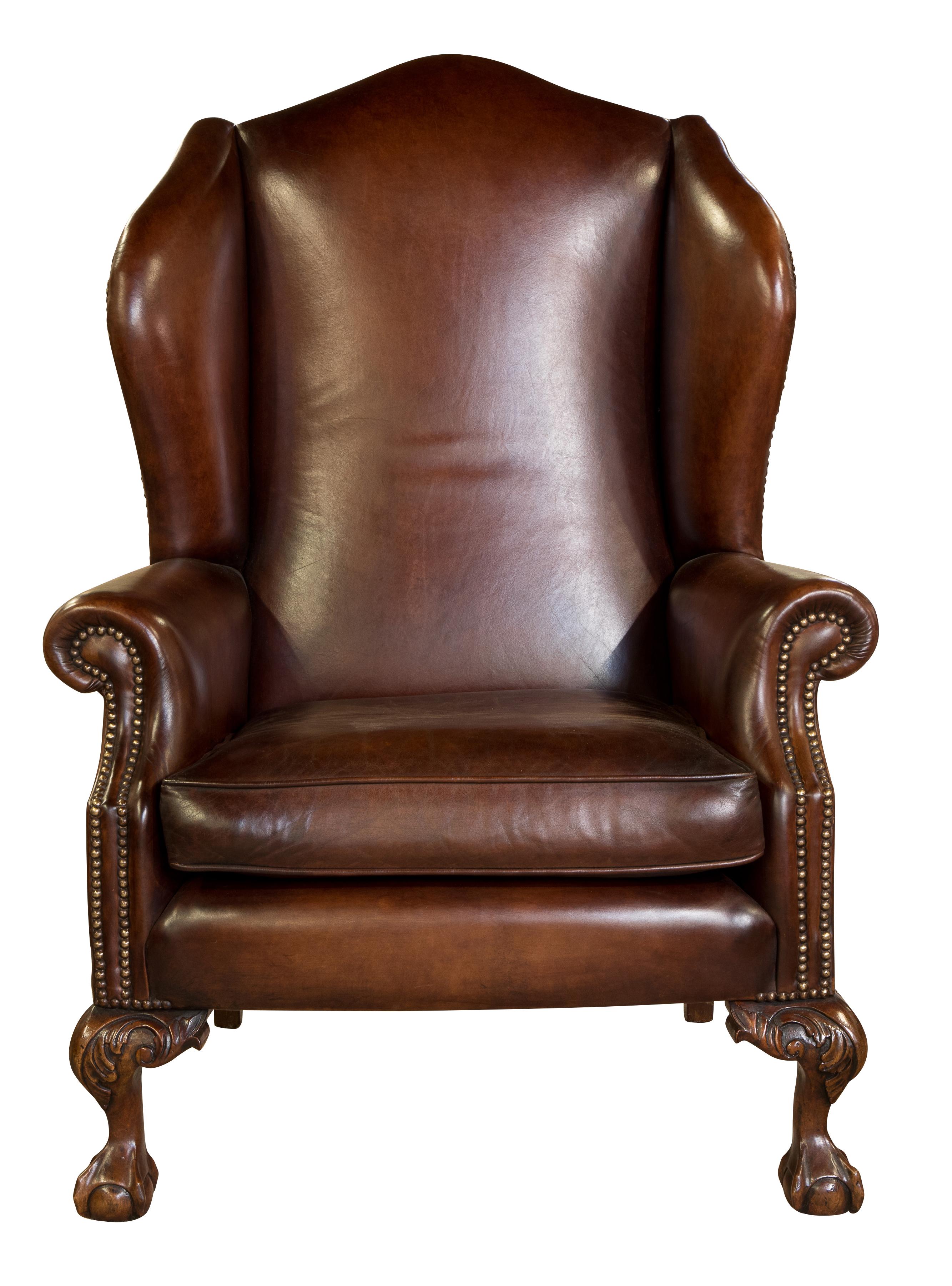Brown leather wing chair on ball and claw legs, circa 1960.