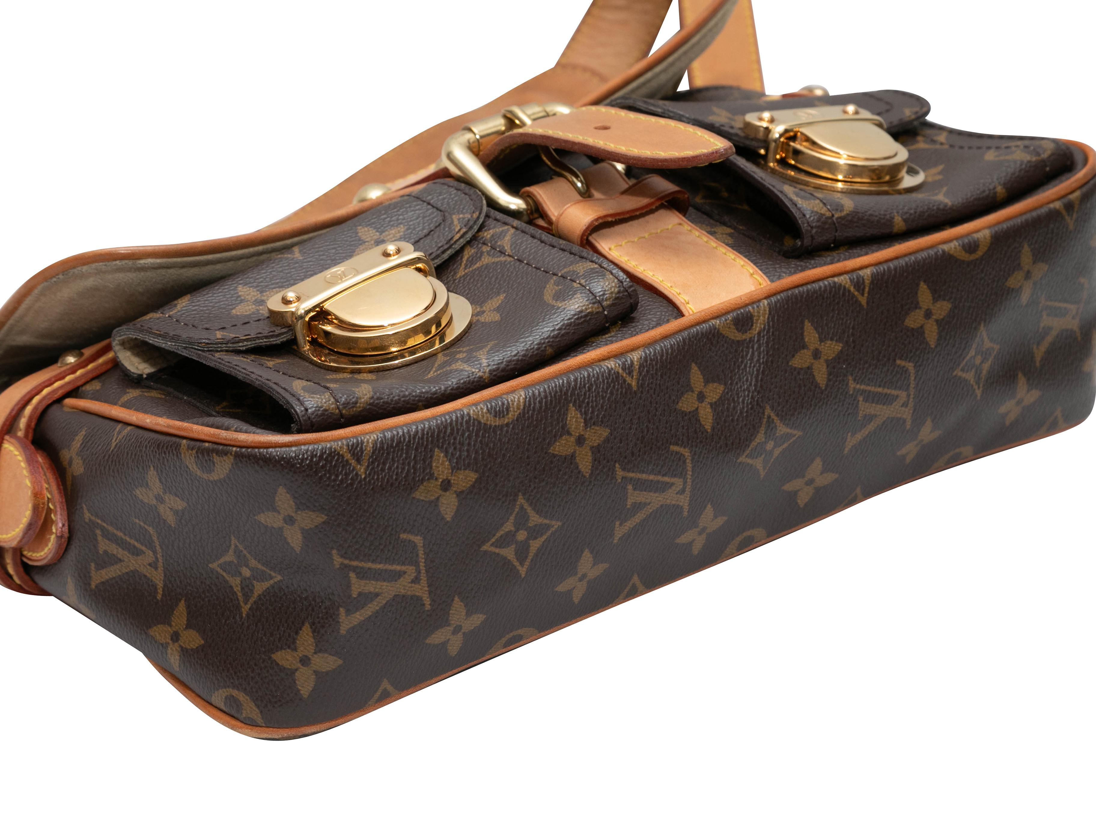 Braune Louis Vuitton Monogram Hudson PM Tasche. Die Hudson PM Bag hat einen Korpus aus beschichtetem Canvas mit Monogrammen, Lederbesatz, goldfarbene Beschläge, zwei Vordertaschen mit Push-Lock-Verschluss, einen einzelnen Schulterriemen und einen