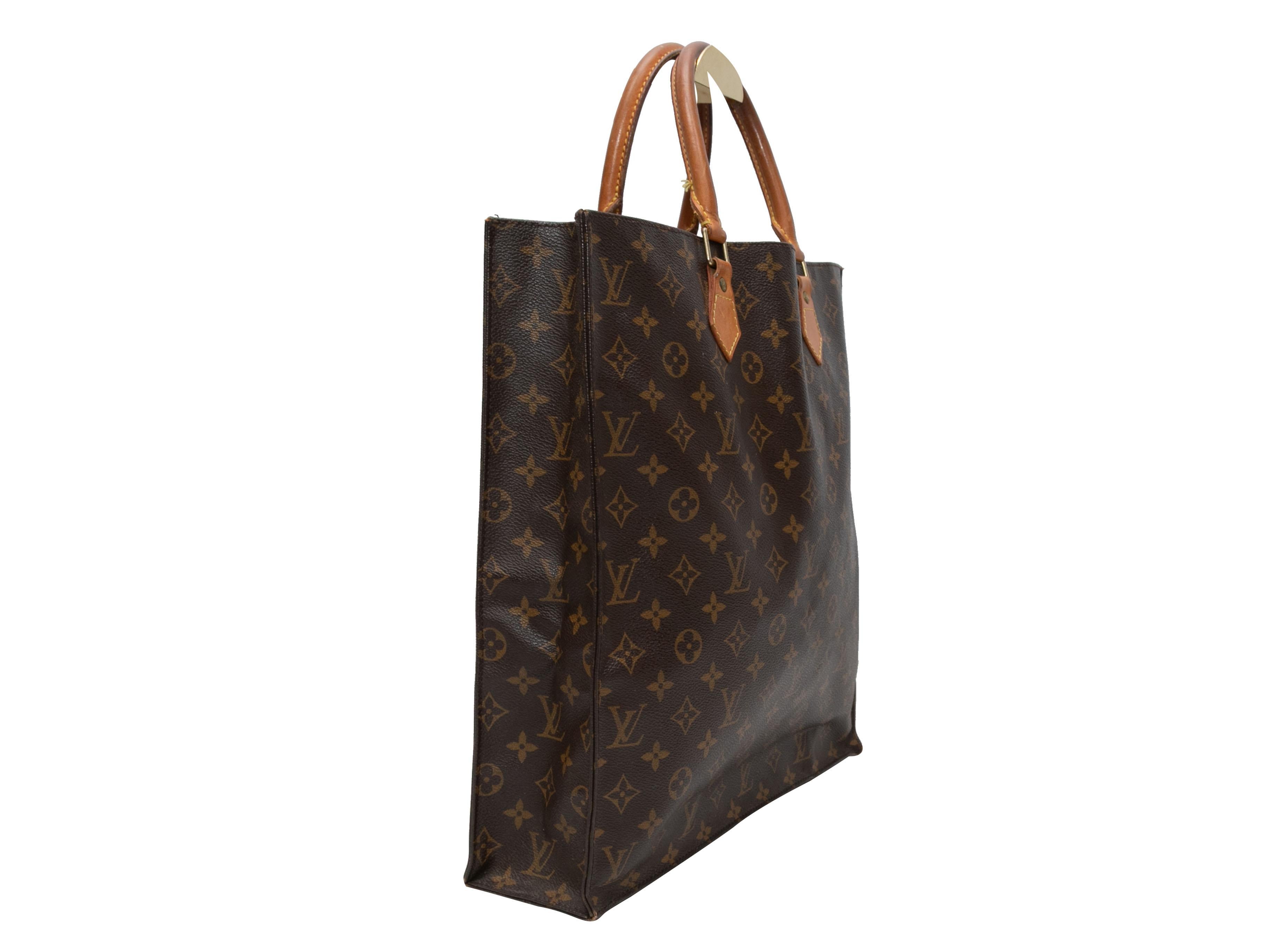 Brown Louis Vuitton Monogram Sac Plat Bag. The Sac Plat Bag features a monogram coated canvas body, leather trim, gold-tone hardware, and dual rolled top handles. 14