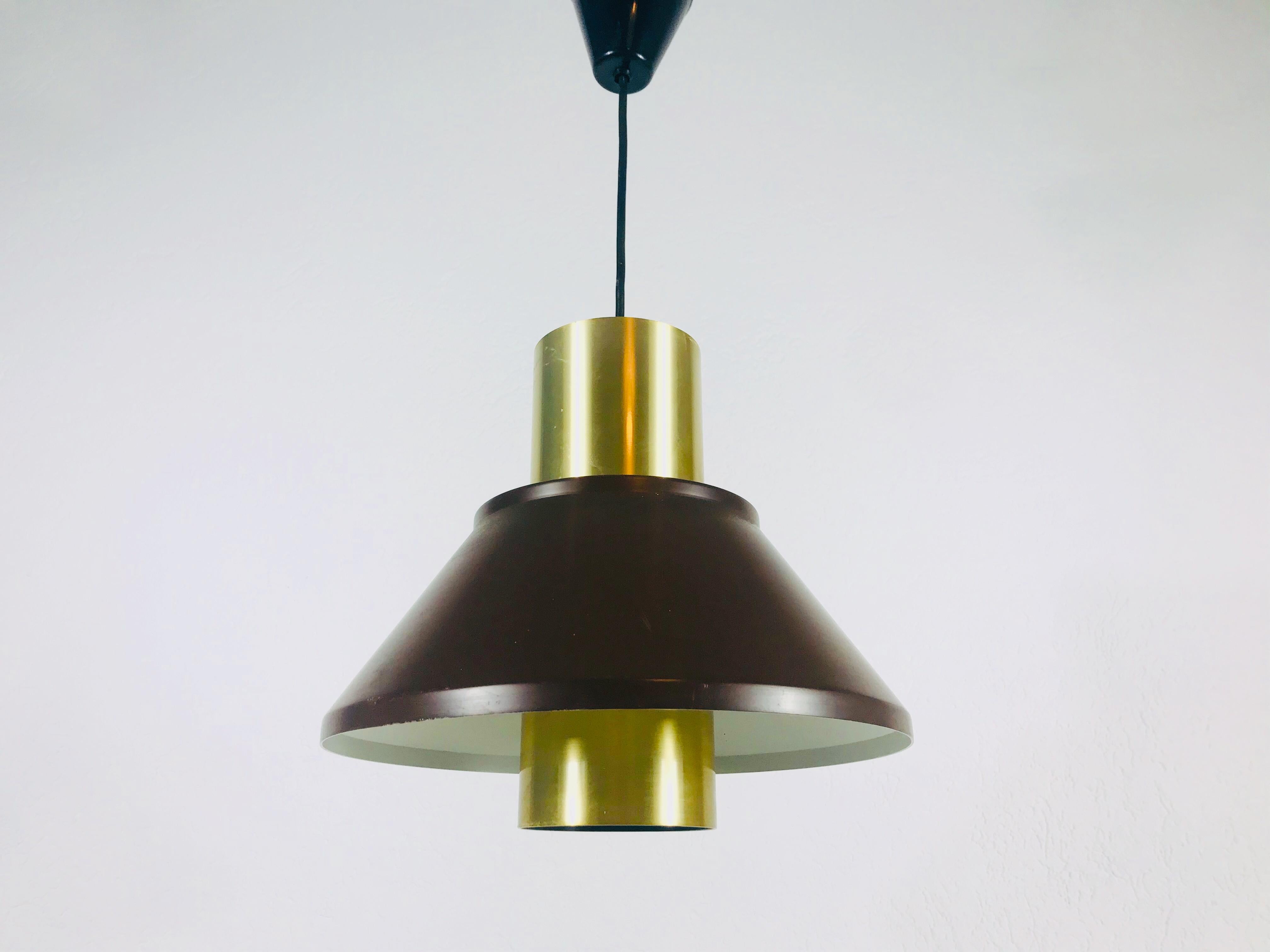 Brown pendant lamp by Fog and Mørup made in Denmark in the 1970s. It is made from thin aluminium and brass

Measures: Height 28-55 cm

The light requires one E27 light bulb.
  