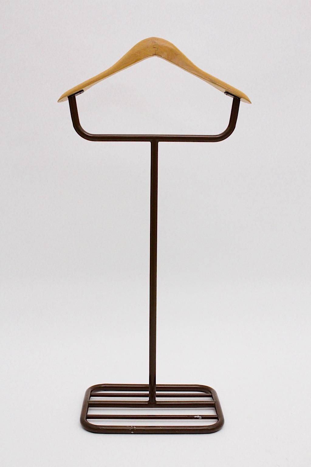 Brown vintage Bauhaus valet or coat rack from metal and beech designed and manufactured 1930s.
A wonderful valet with a beech hanger and a brown lacquered metal construction with a squared base.
Throughout its plain look and feel the valet is very