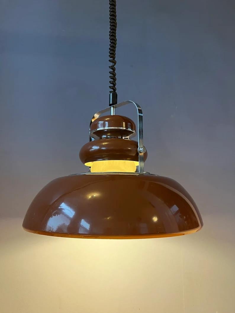 Vintage brown space age age pendant lamp by Anvia. The lamp is beautifully layered with brown parts and chrome parts. The height of the lamp can easily be adjusted with the rise/fall mechanism. The lamp requires one E27/26 (standard)