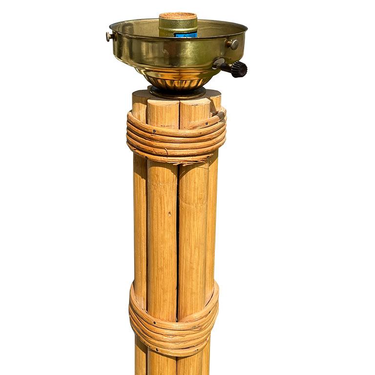 Lampe de table en bambou et rotin fendu du milieu du siècle. Cette pièce mesure près de 21 pouces de haut et est fixée à une base ronde en laiton. Il se compose de tiges rondes de bambou ou de rotin qui sont reliées en deux points autour du centre
