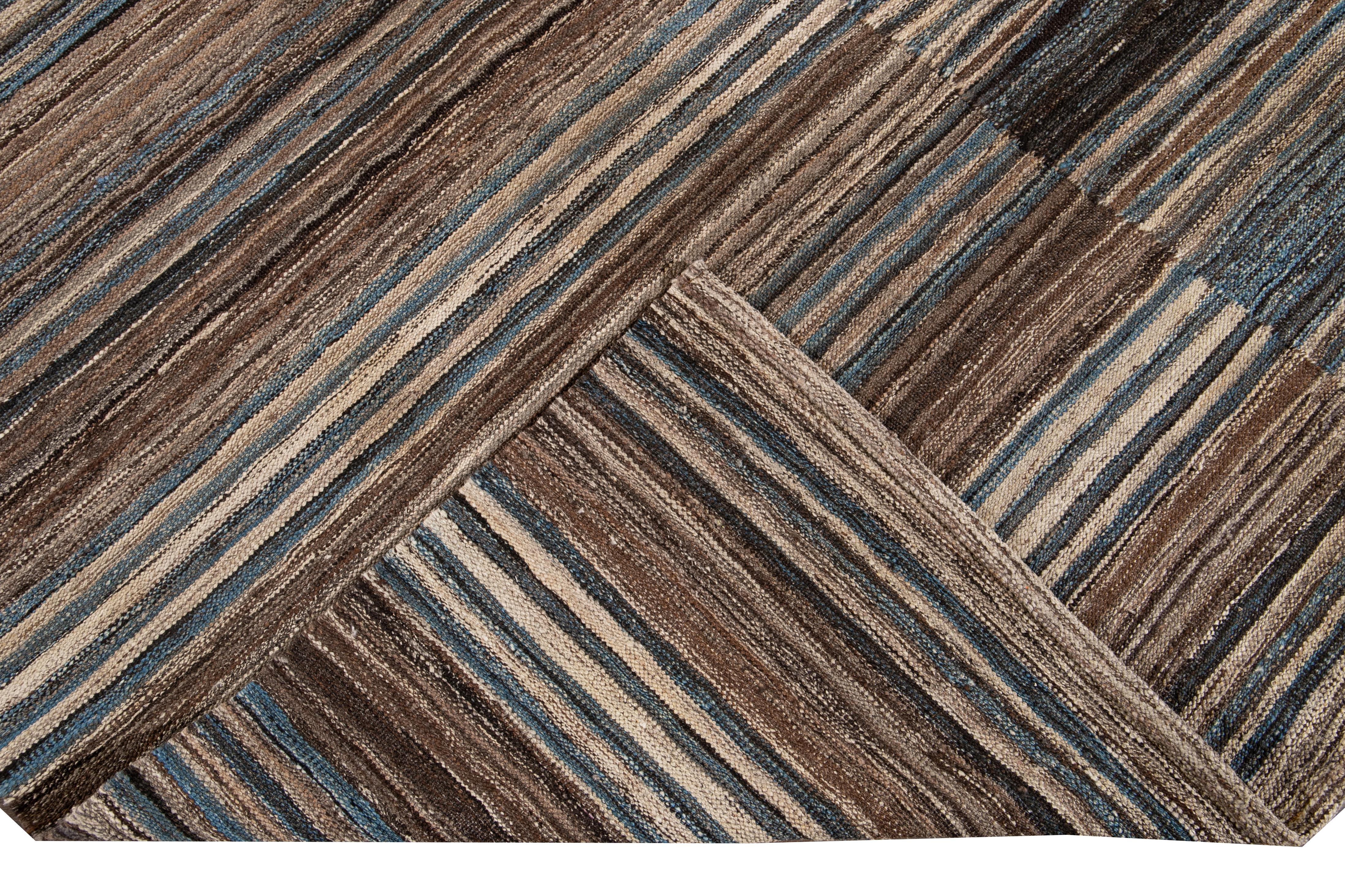 Schöner moderner, handgewebter Wollteppich in Flachgewebeoptik. Dieser Kelimteppich hat ein braunes Feld mit blauen und beigen Akzenten in einem wunderschönen geometrischen expressionistischen Muster.

Dieser Teppich misst: 10'4