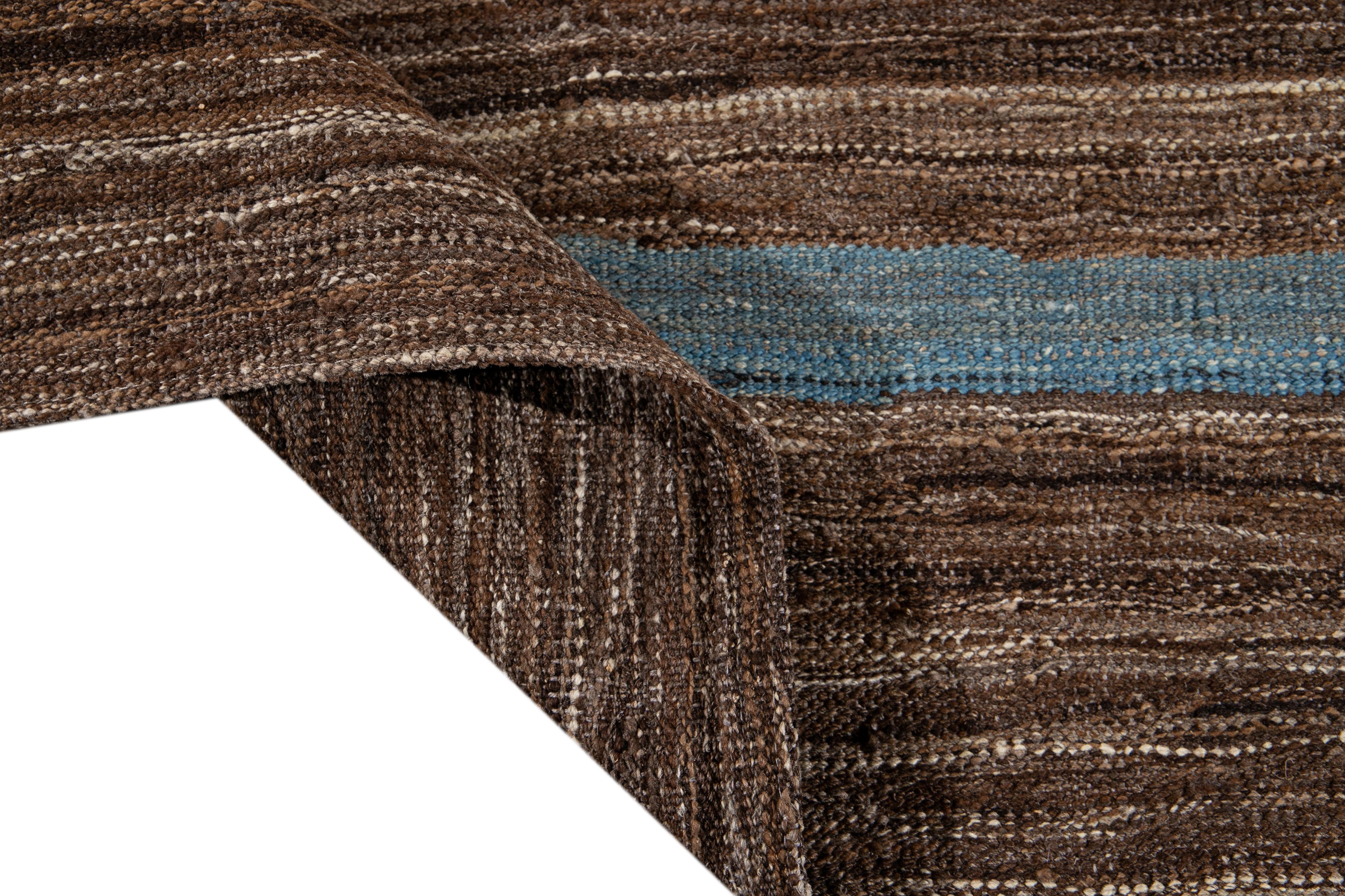 Schöner moderner flachgewebter Kilim Handmade Wollteppich mit braunem Feld. Dieser Kelimteppich hat blaue Akzente in einem wunderschönen abstrakten expressionistischen Design.

Dieser Teppich misst: 9' x 12'1
