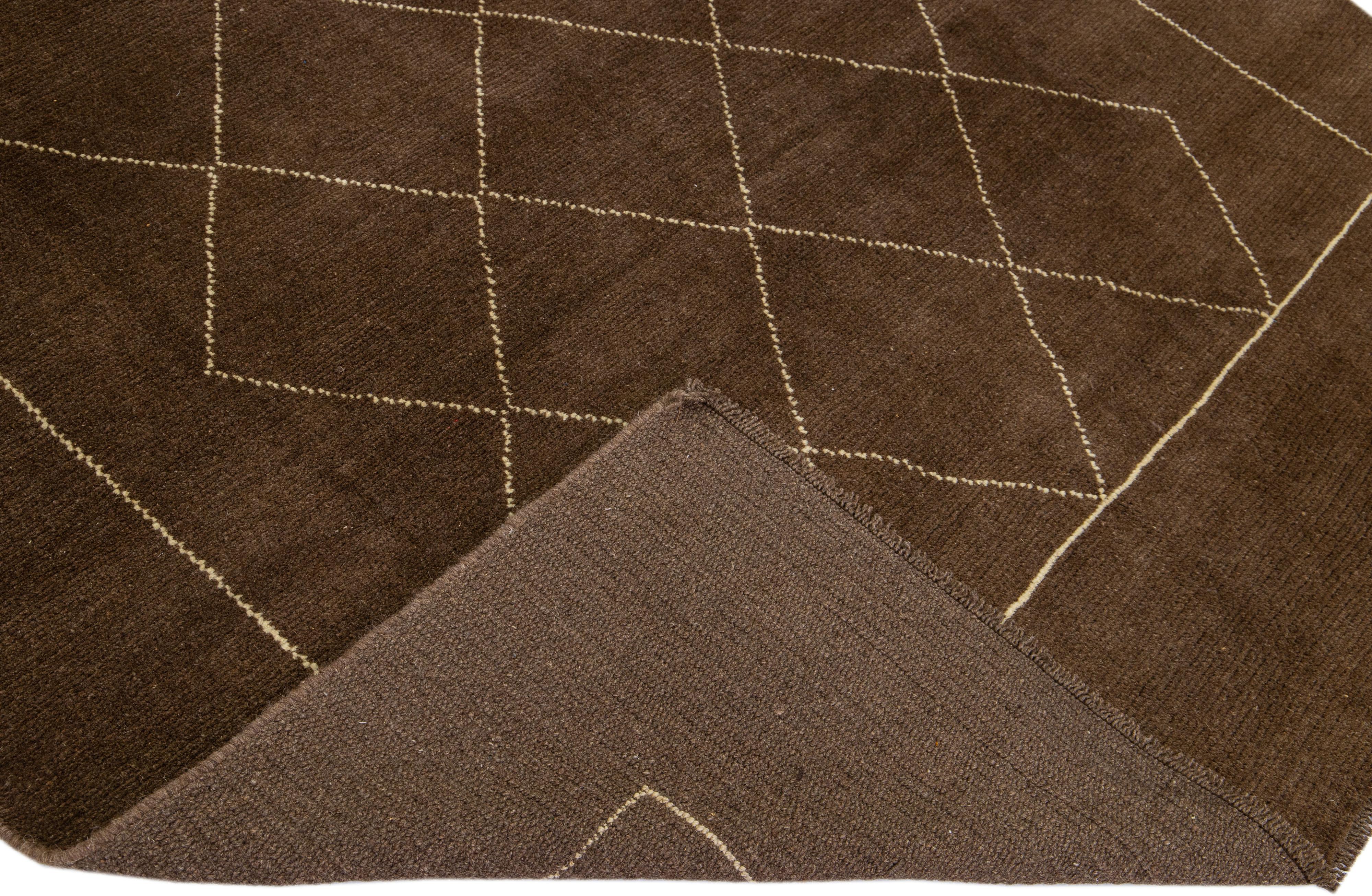This beautiful Moroccan-style handmade wool rug makes part of our Northwest collection and features a brown color field and beige accents in a gorgeous geometric tribal design.

This rug measures: 6'6
