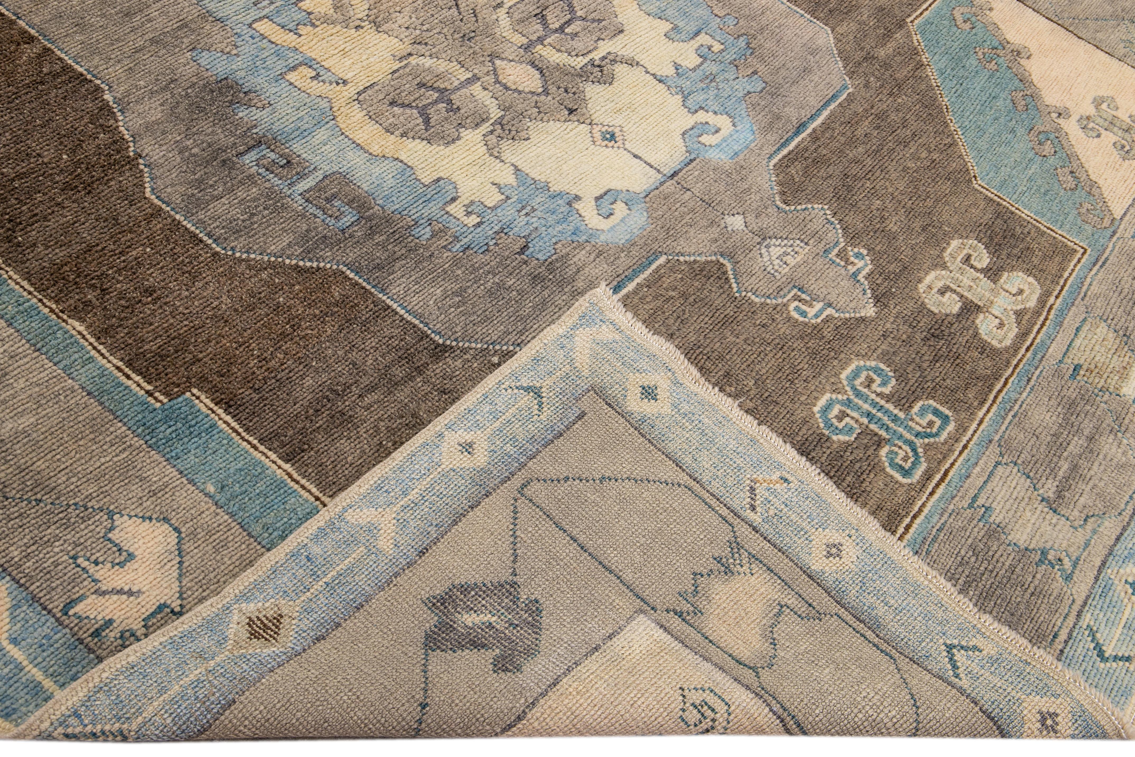 Beautiful modern Oushak hand-knotted wool rug with a brown field. This Oushak rug has a beige and blue accents layout a gorgeous geometric medallion floral design. 

This rug measures: 7'11