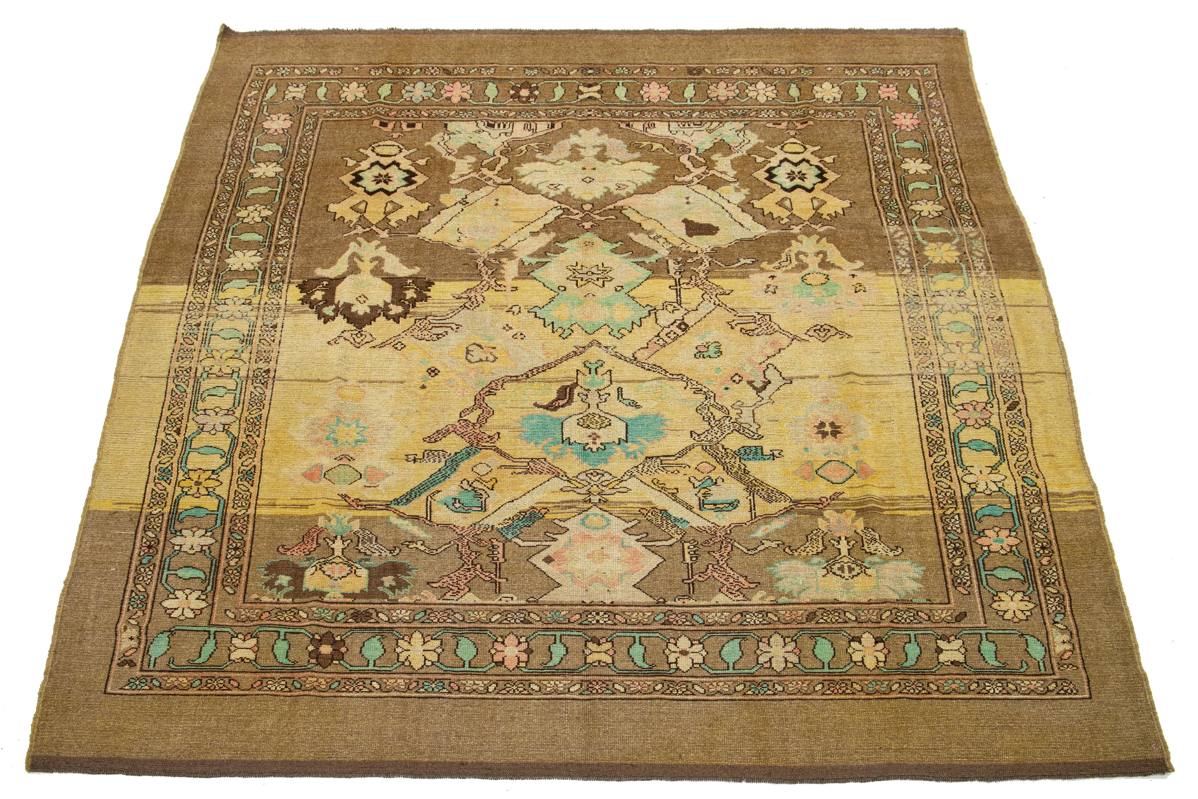 This hand-knotted wool rug features a light brown base and is part of the Apadana Revival Collection. Its striking botanical floral design is enhanced by a blend of teal, peach, beige, and yellow accents.

This rug measures 8'4