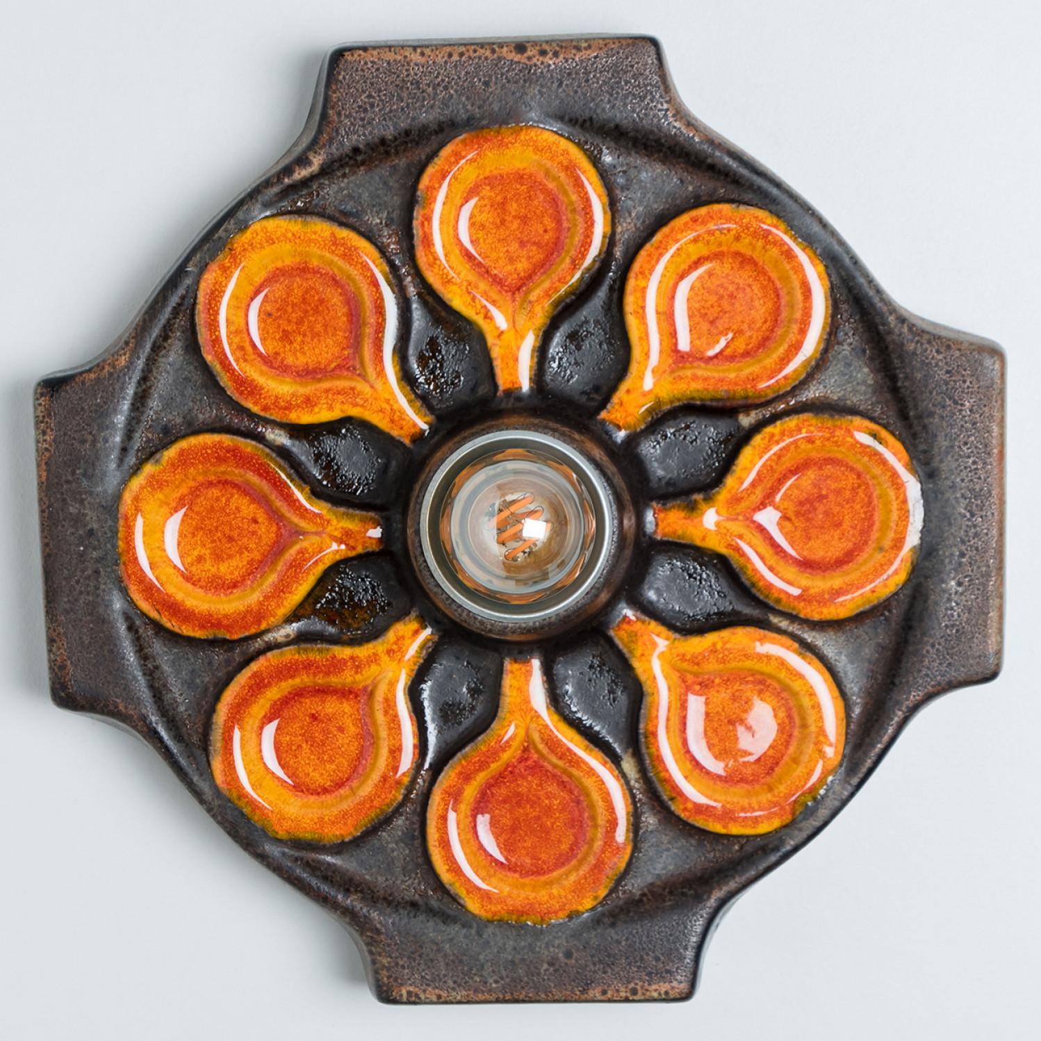 Stunning wall lamp with an unusual shape, made with rich brown and orange colored ceramics, manufactured in the 1970s in Germany. We also have a multitude of unique colored ceramic light sets and arrangements, all available on the frontstore.