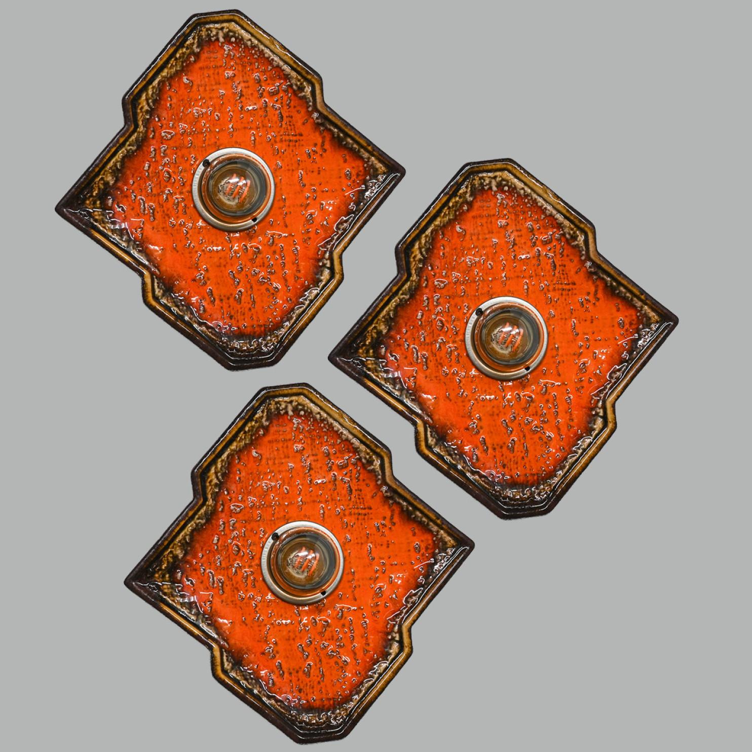 Brown and orange diamond-shaped ceramic wall lights/flush mounts Germany in the 1970s.

This lights have a unusual shape. This makes it possible to create a playful arrangement. Can also be used as flush mounts.

We used amber light bulbs (see