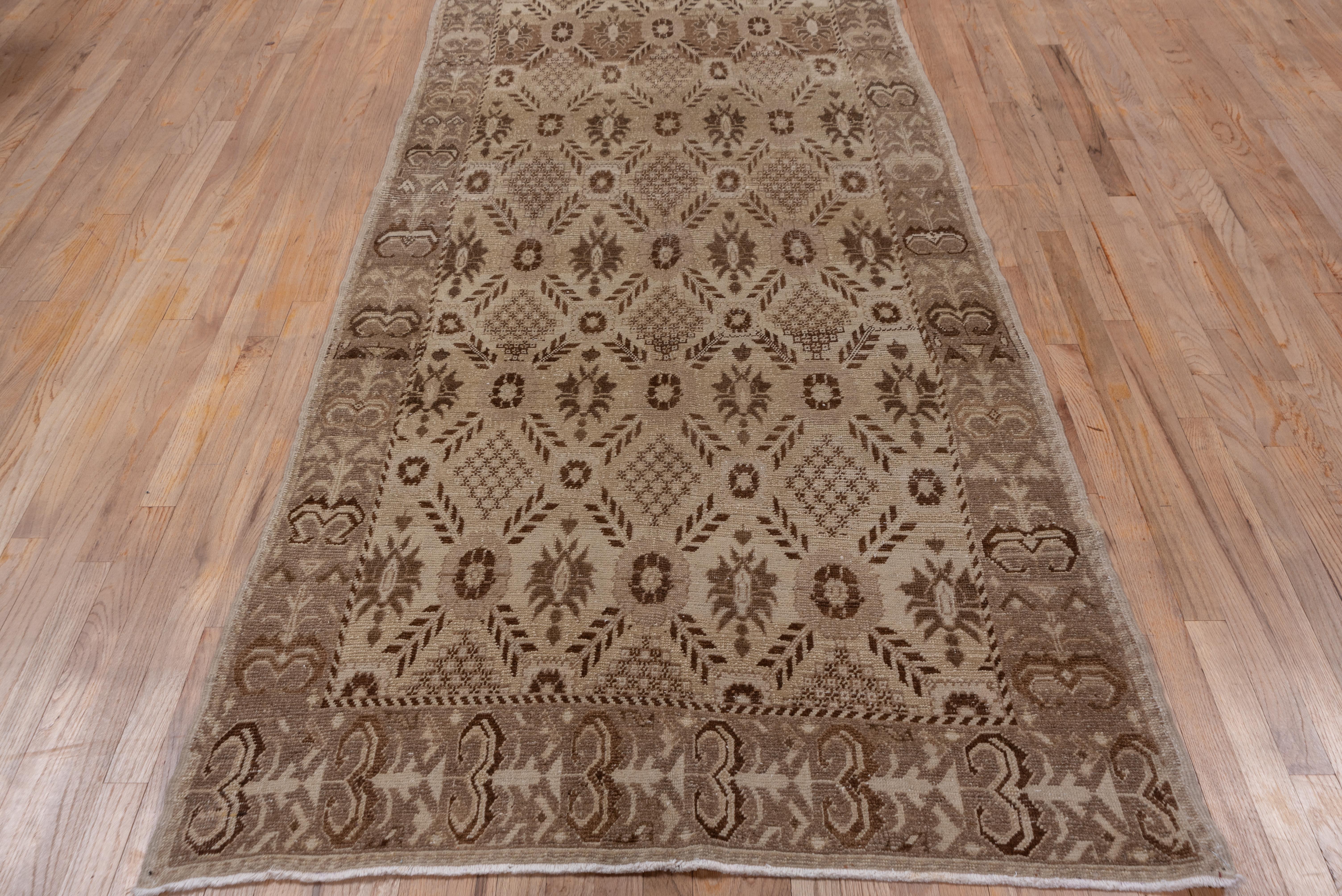 This Persianate design of feathery diagonal leaves forms a lattice with rosette vertices and enclosing simple jagged palmettes., on the straw-beige ground, detailed in sienna brown. The progressive flower module main border is also Persian in