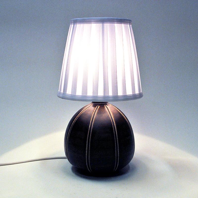 A special shaped stoneware table lamp produced by Rörstrand, Sweden 1940s. Melon like shape with golden earth brown tones and a matt finish. Perfect in every room with a suitable lampshade. 
Measures: h 25 cm include lampholder x 17cm d. New