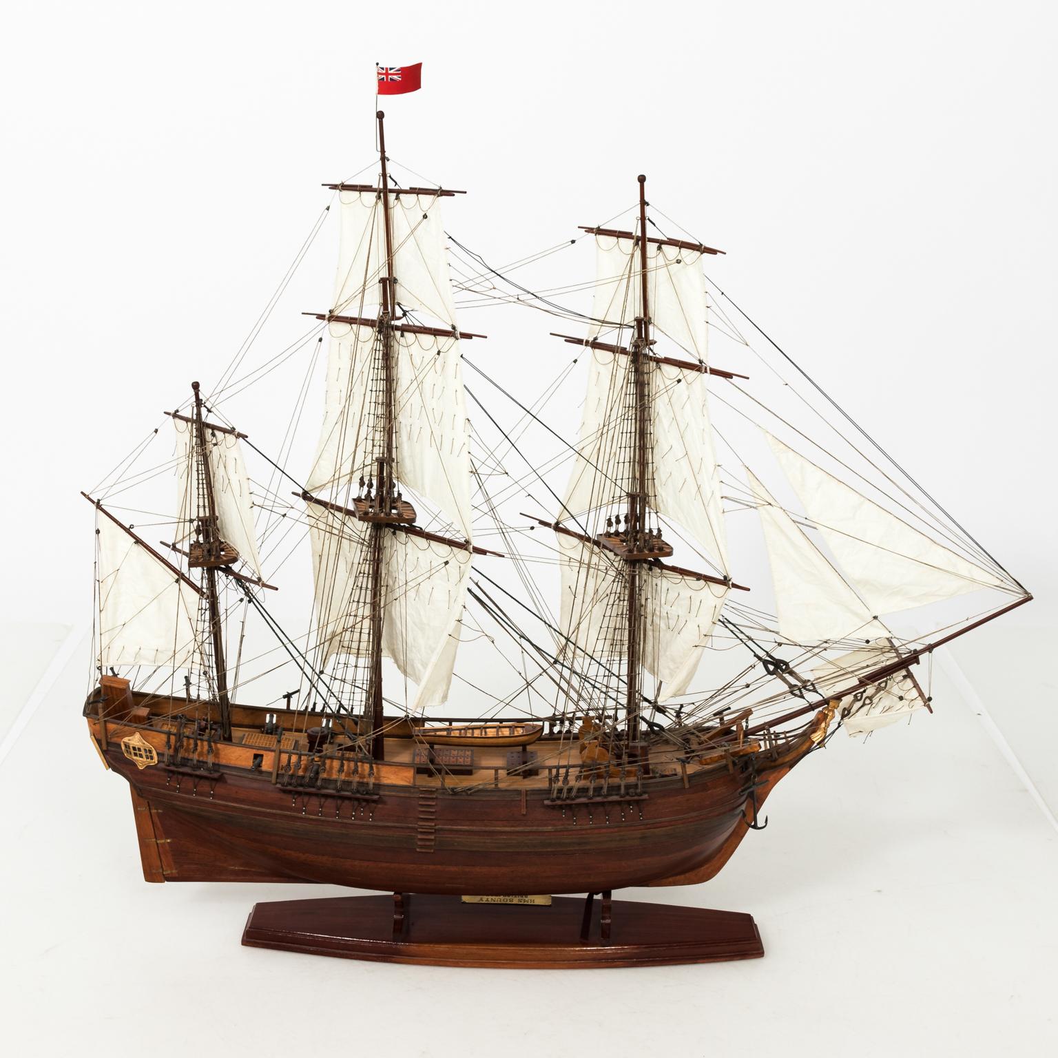 Contemporary brown painted model of a British naval ship with six sales and British civilian naval flag.
  