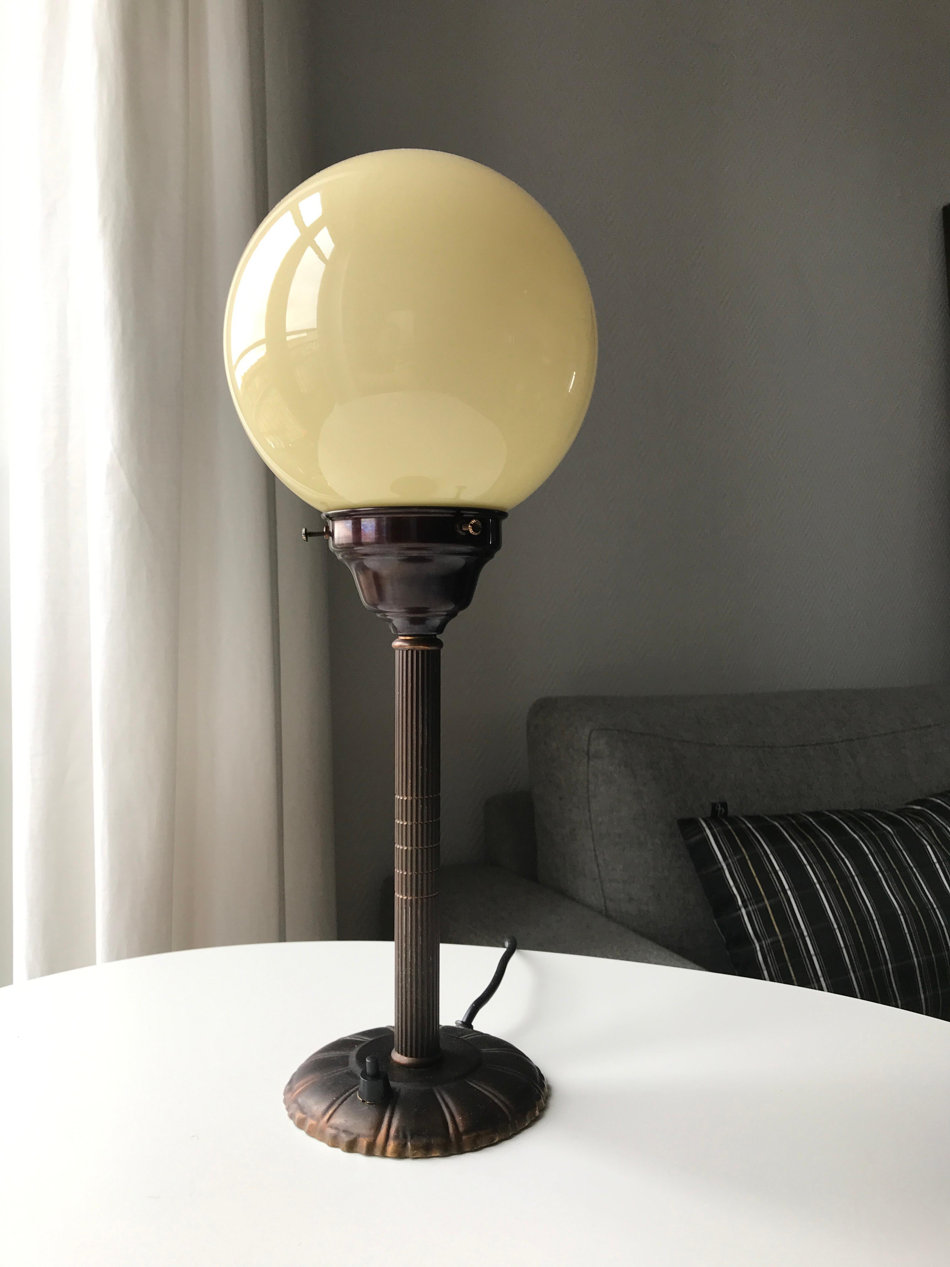 Art Deco Table Lamp Denmark. Base in dark brown patinated brass with symmetric decoration on plinth and tube. Most likely manufactured by late danish lamp factory Fog & Mørup. Layer by layer opaline yellow surface opaline glass. Replaced glassholder