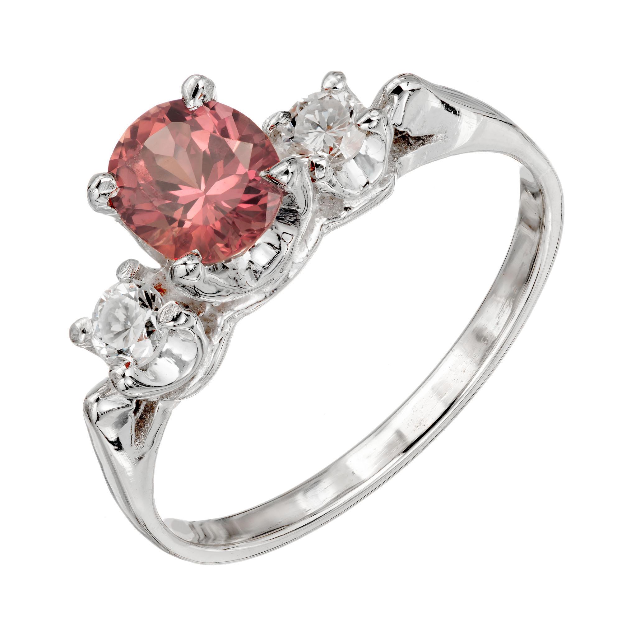 Pink brown sapphire and white diamond three-stone engagement ring. Natural no heat oval natural Padparadscha center sapphire that changes from brown to pink in different lighting, accented with 2 side round side diamonds in a three-stone gold