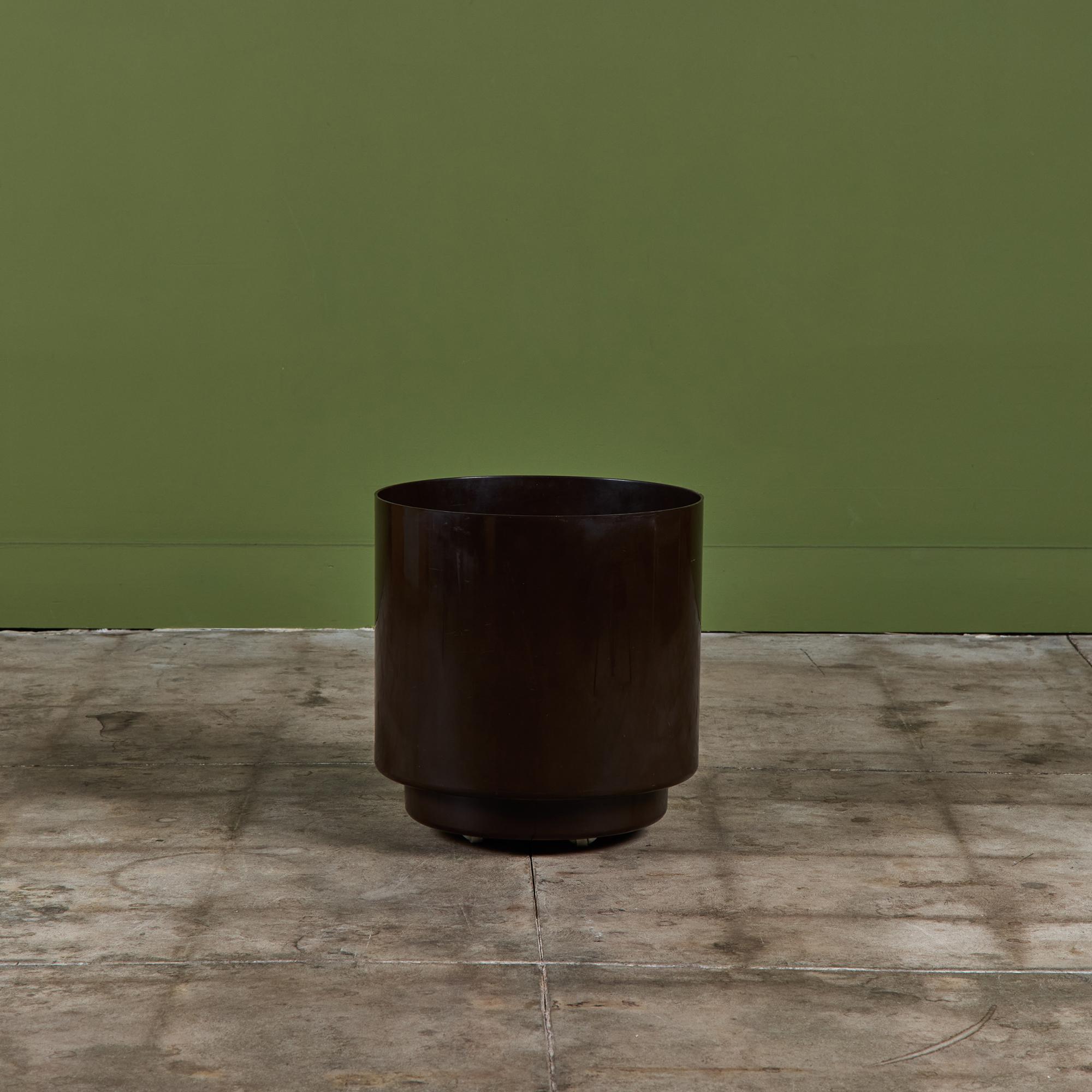 Planter from Italian design house Kartell, designed by Anna Castelli Ferrieri, c.1970s, USA. The brown planter features a cylindrical plastic form with four casters at the bottom.
Three available, priced individually.

Dimensions
16.25” diameter x