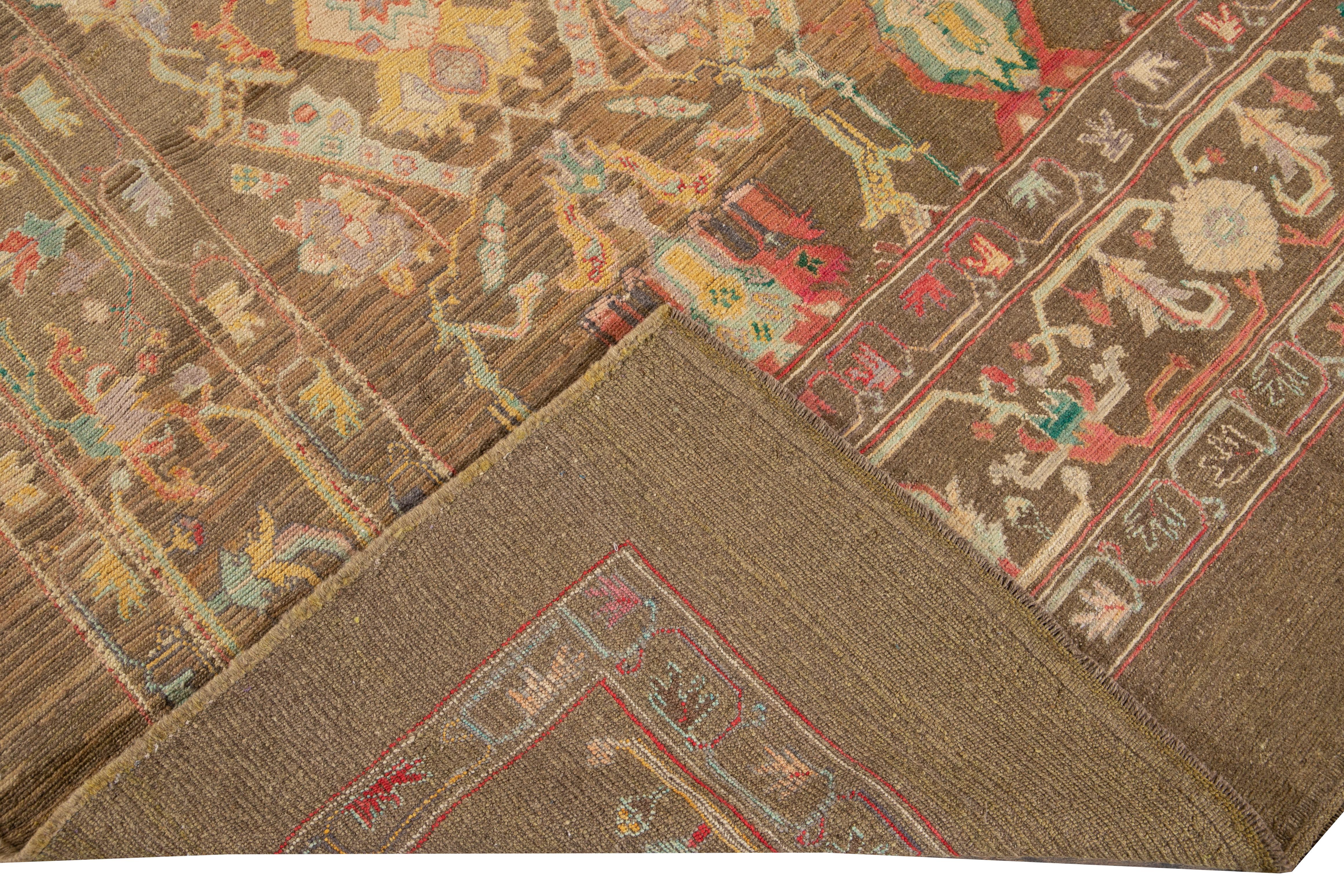 Preciosa alfombra moderna de lana anudada a mano con campo marrón. Esta alfombra de la Colección Revival tiene brillantes detalles multicolores sobre un precioso diseño geométrico floral.

Esta alfombra mide 8'1