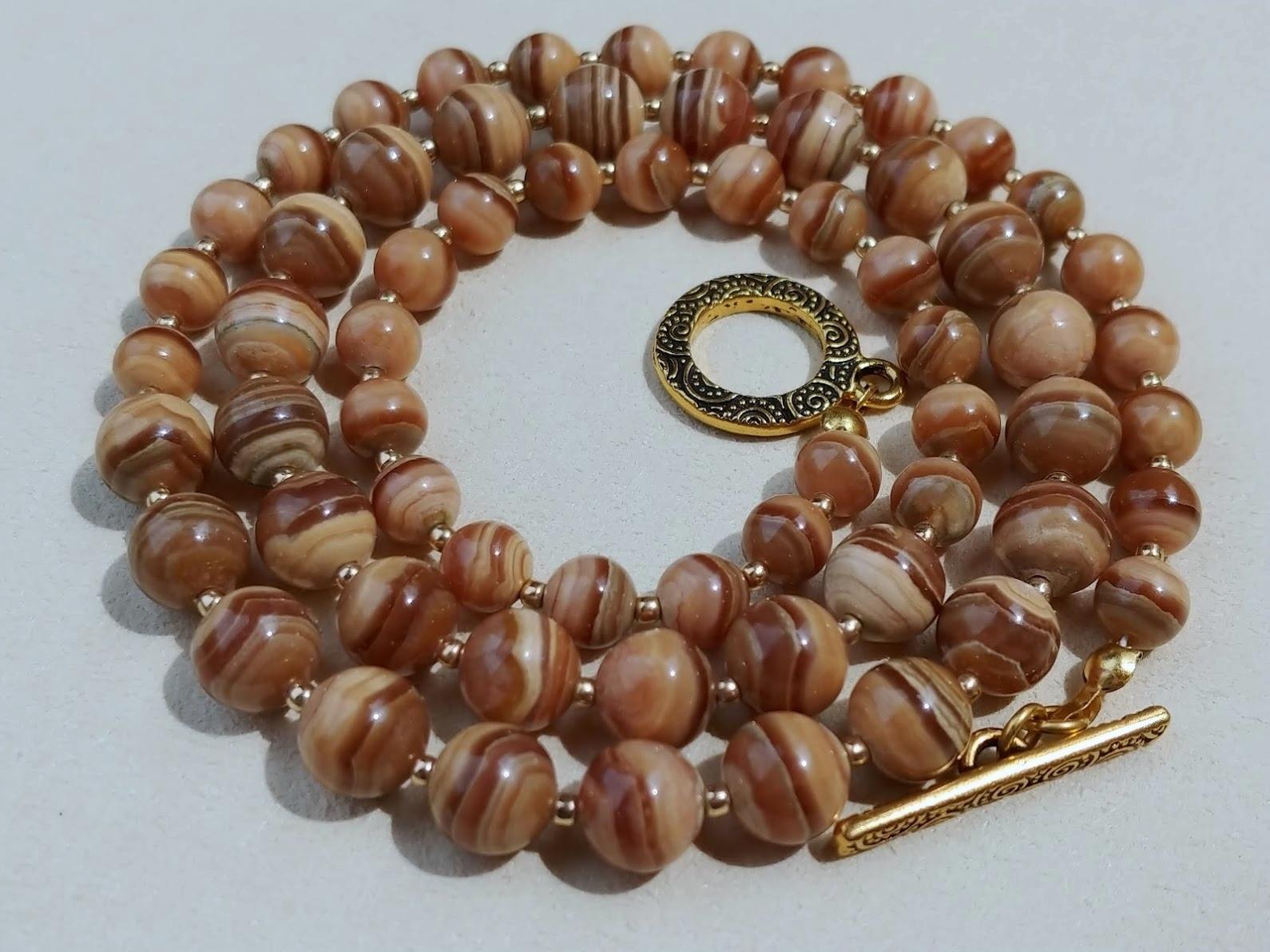 The length of the necklace is 23 inches (58cm). The size of the smooth round beads varies from 6.5 to 8.5 mm.
Natural light brown rhodochrosite. Authentic, natural color not treated in any way. Superior higher grade! Beautiful, interesting peachy