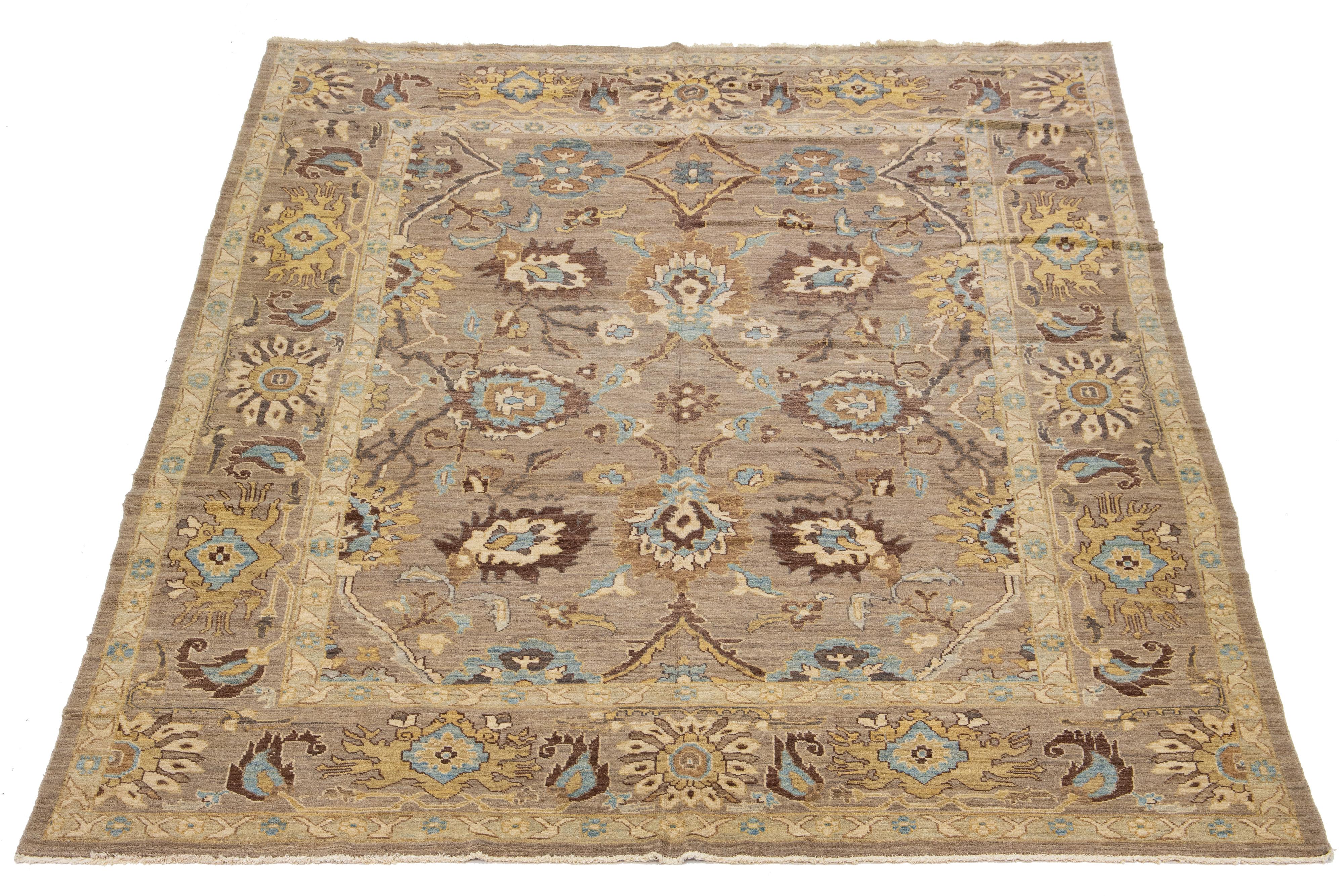 This is a modern Persian Sultanabad rug with a brown field, a wide border, and an all-over light blue and yellow pattern.

This rug Measures 9'9'' x 12'8''.