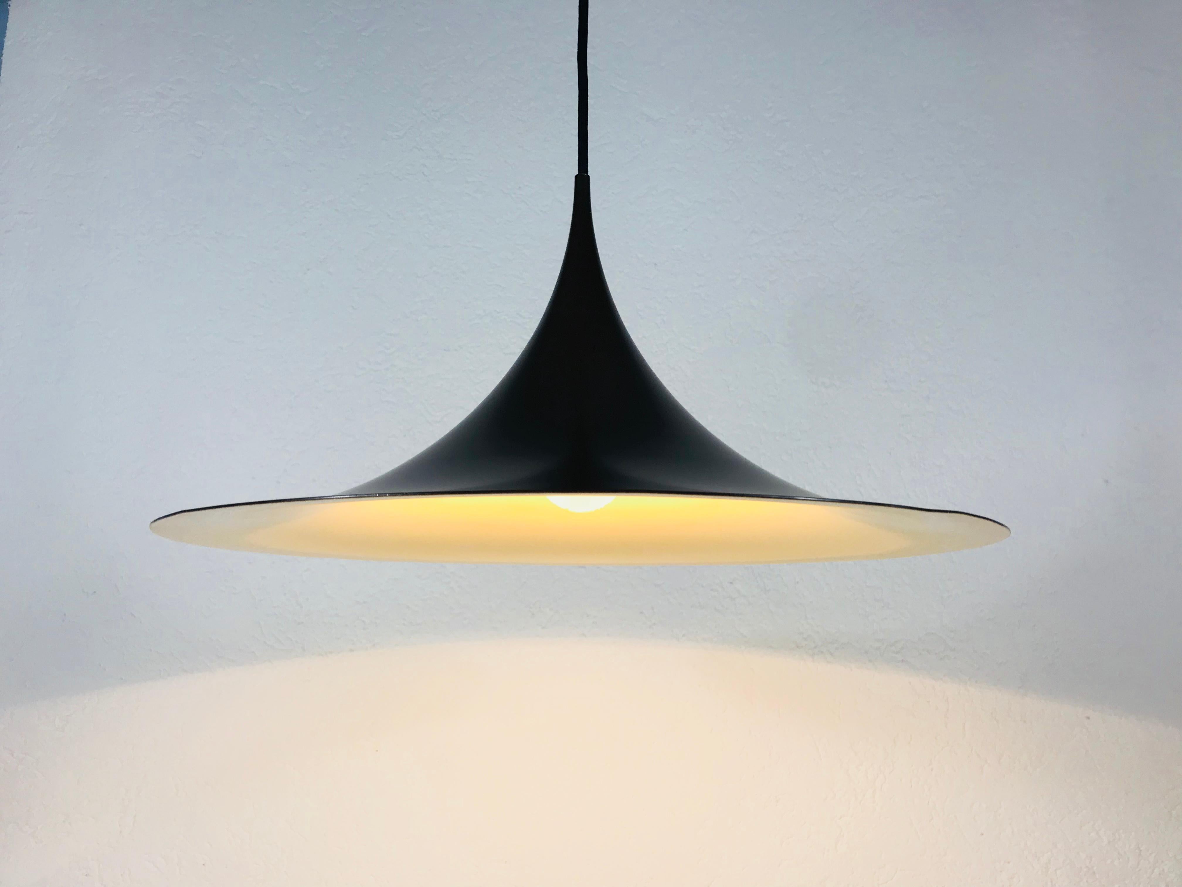 Black pendant lamp by Fog and Mørup made in Denmark in the 1970s. The light has the shape of a witches hat. It is made from thin aluminium.

The light requires one E27 light bulb.
  