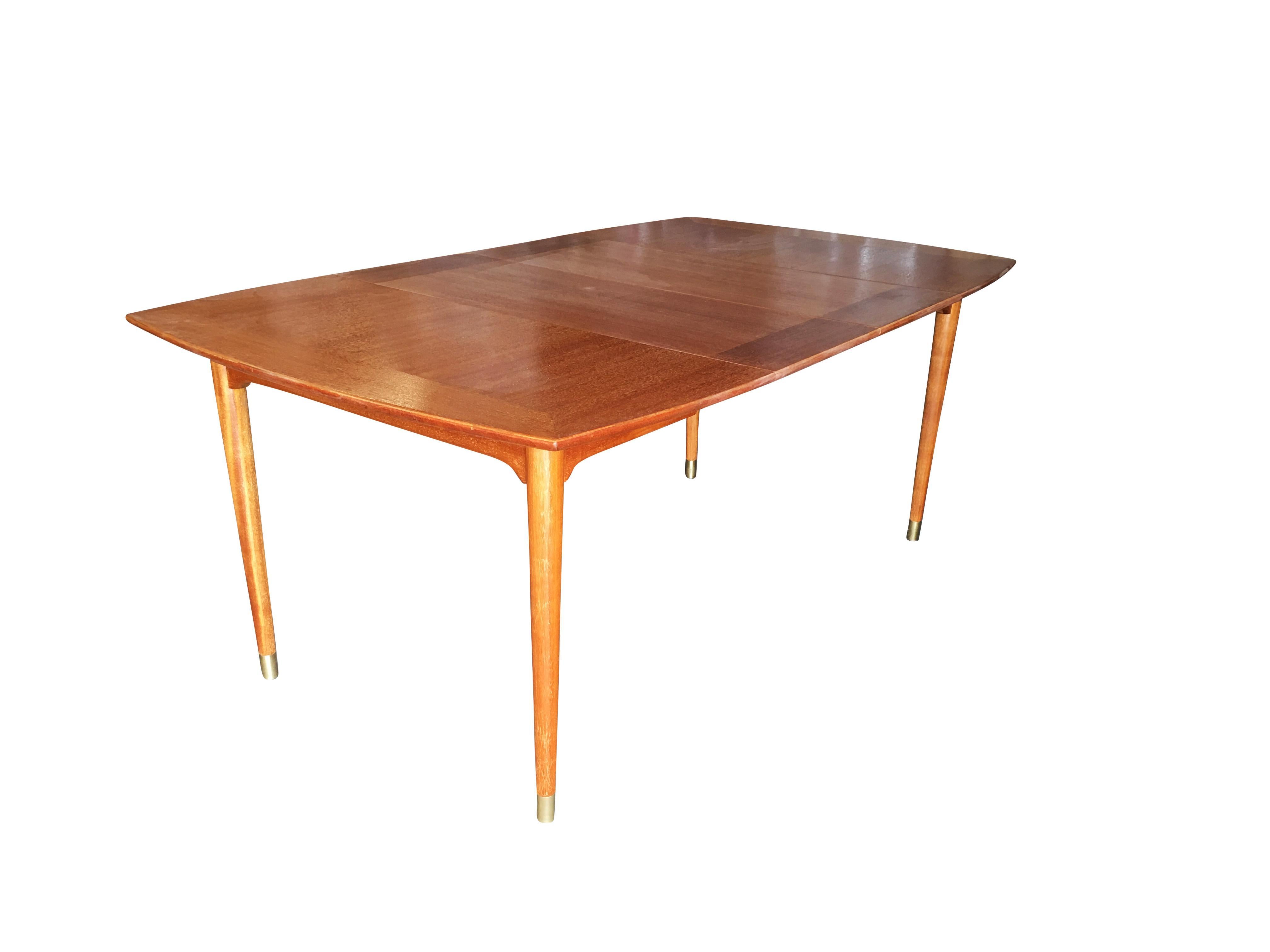 Large midcentury mahogany extendable dining table by John Keal for Brown Saltman featuring well shaped tapered legs and a petite design.
The table features great compact 44