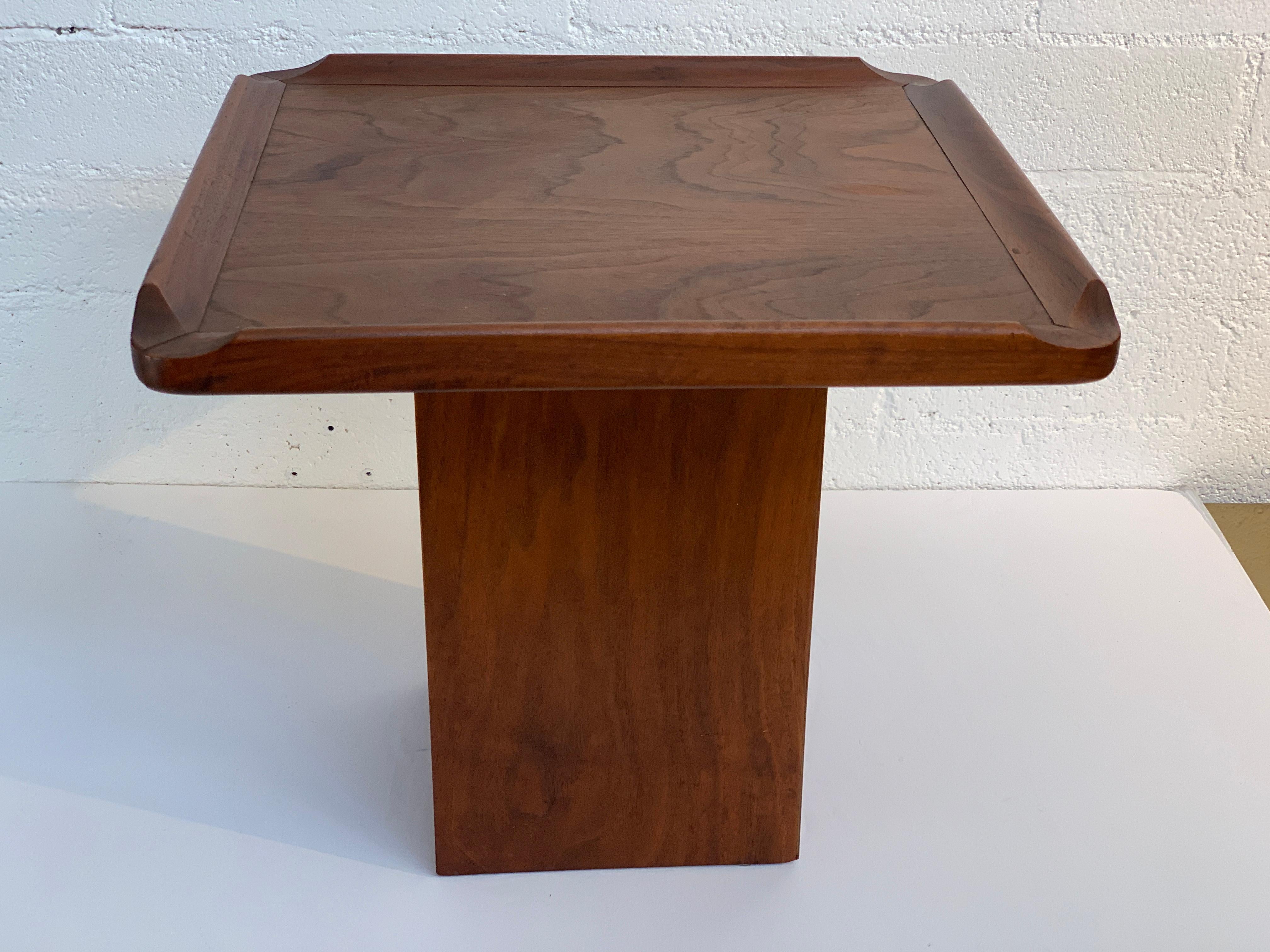 A small table in walnut veneer by Brown Saltman. Still retains the label underneath. Original condition with age appropriate wear and imperfections.