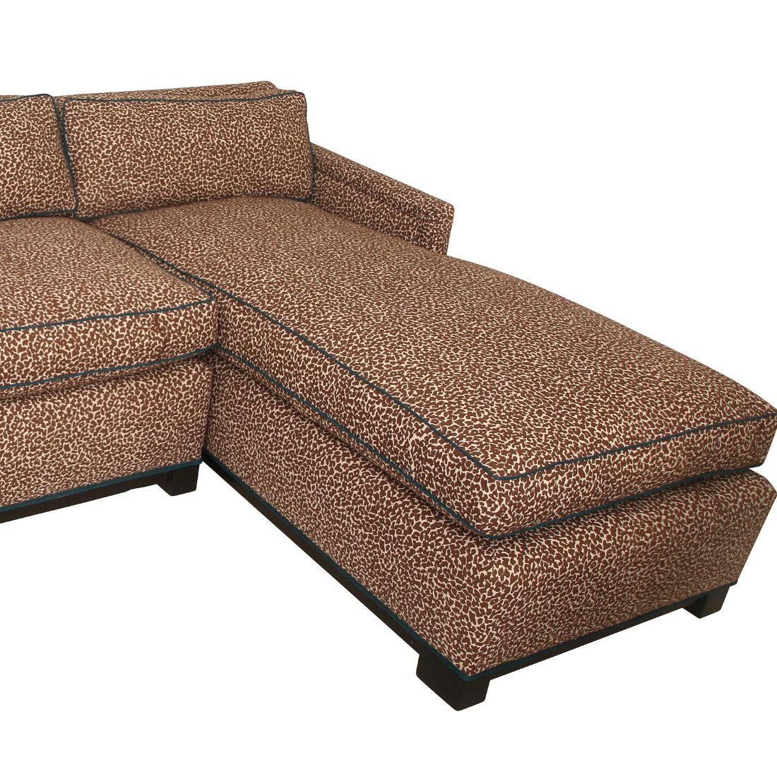 This brown sectional sofa upholstered in a custom Sister Parish fabric with a textured pattern, and custom teal trim. The sofa includes a chaise lounge extension on the right-hand side, offering a spacious and comfortable seating area. The trim and