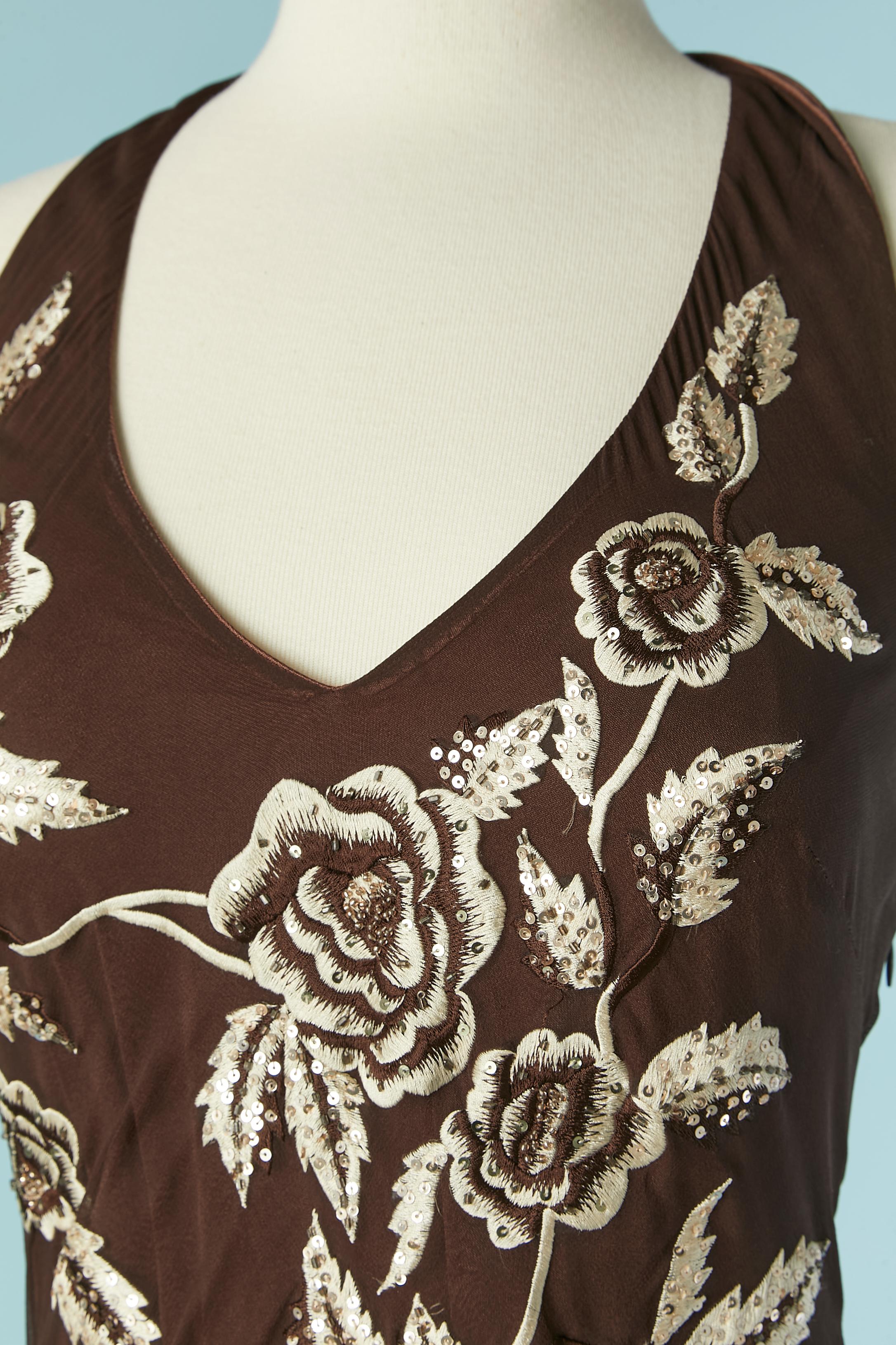 Abito da sera senza schienale in seta marrone con ricami in filo, paillettes e frange. 
Fodera in rayon. Reggiseno imbottito. Chiusura con zip e gancio a sinistra. Lacci sulla parte centrale della schiena. 
Lunghezza totale senza frange = 112
