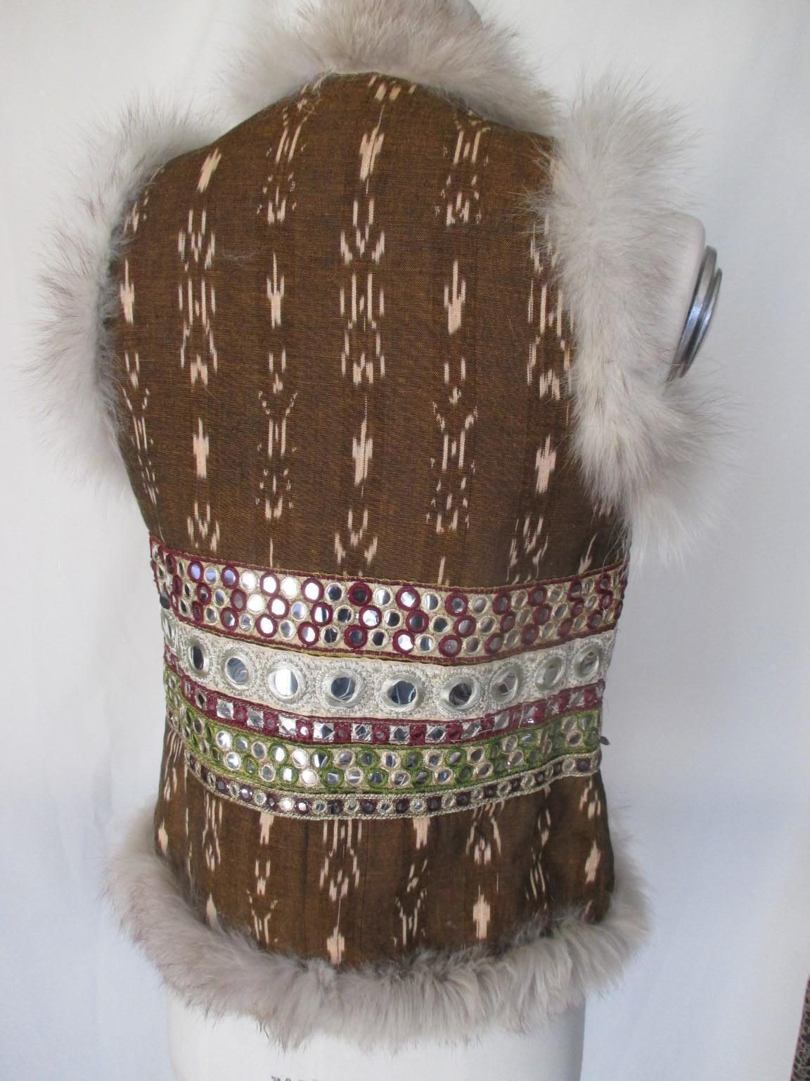 This beautiful vest is with fox fur embroidered and silver details

We offer more exclusive fur items, view our frontstore

Details:
2 pockets, no buttons, no label
Ikat fabric
Silver details
Pre owned condition
Size fits as small, see section