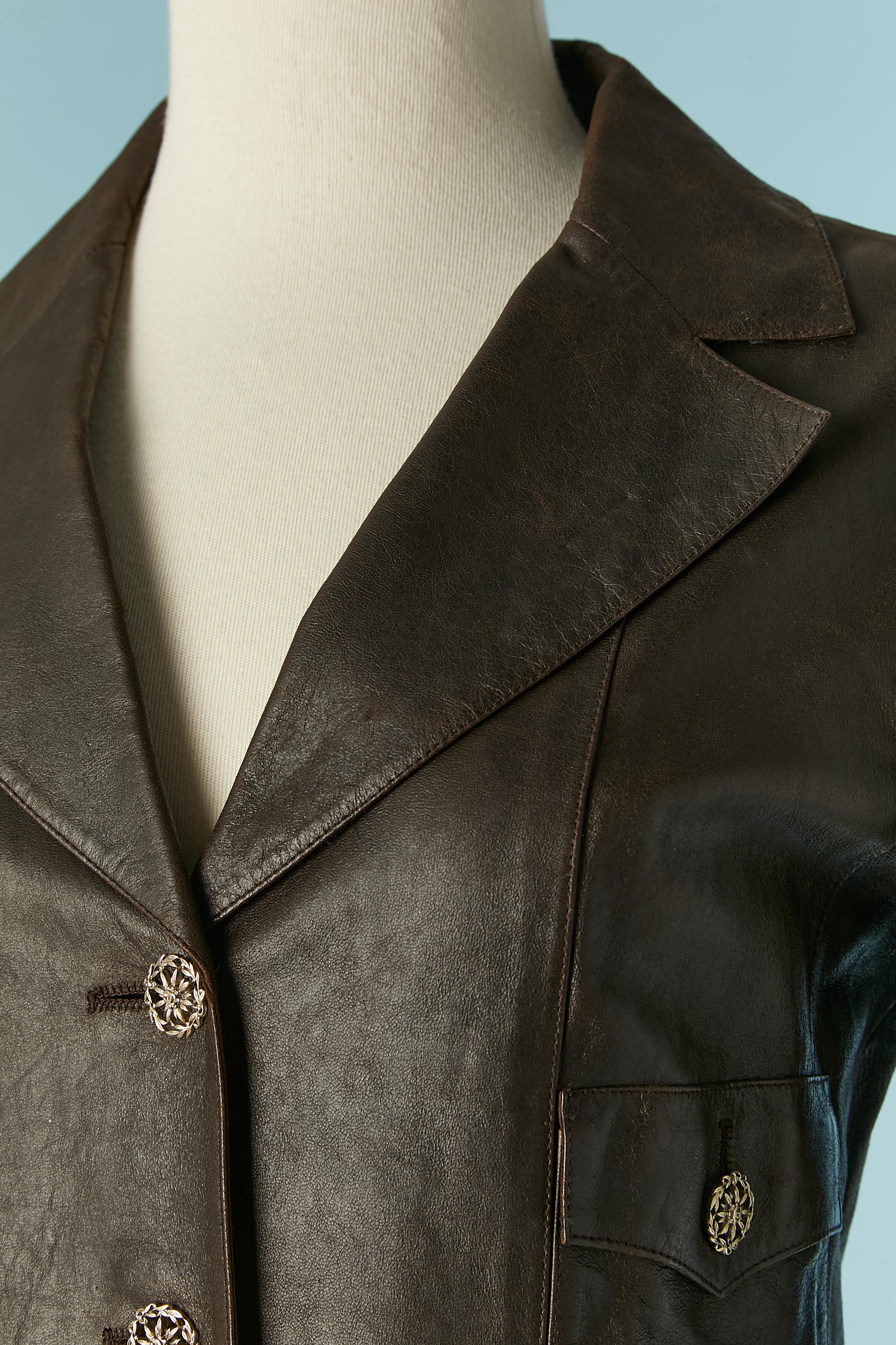 Brown single breasted leather jacket with silk lining. Half-belt in the back on the waist. 
Branded buttons closure on the middle front and on the pockets. Cut-work. 
SIZE 34 (Fr) S 