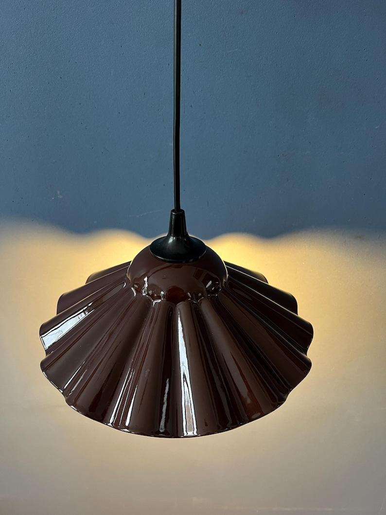Pequeña lámpara colgante flor de esmalte de estilo Art Déco. Esta antigua lámpara está hecha de metal esmaltado fino y tiene un cálido color marrón. La lámpara requiere una bombilla E27/26 y actualmente.

Más información:
Materiales: Metal
Periodo: