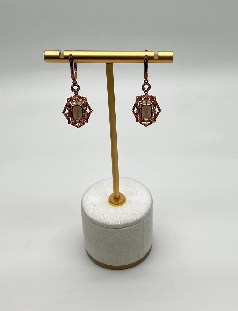 Ein raffiniertes Paar Ohrringe mit einem auffälligen Design und sechseckigen Fassungen. Jeder Ohrring zeigt einen zentralen Quarz mit einem tiefen, satten Farbton, der elegant von einer zarten Metallarbeit umrahmt wird. Die Ohrringe hängen an einem