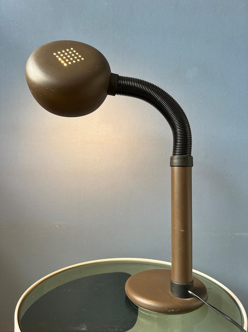 Space age table lamp with easily adjustable arm and shade. The black arm allows you to position the lamp in any way desirable. The lamp requires one E27/26 (standard) lightbulb and currently has an EU-plug.

Additional information:
Materials: Metal,