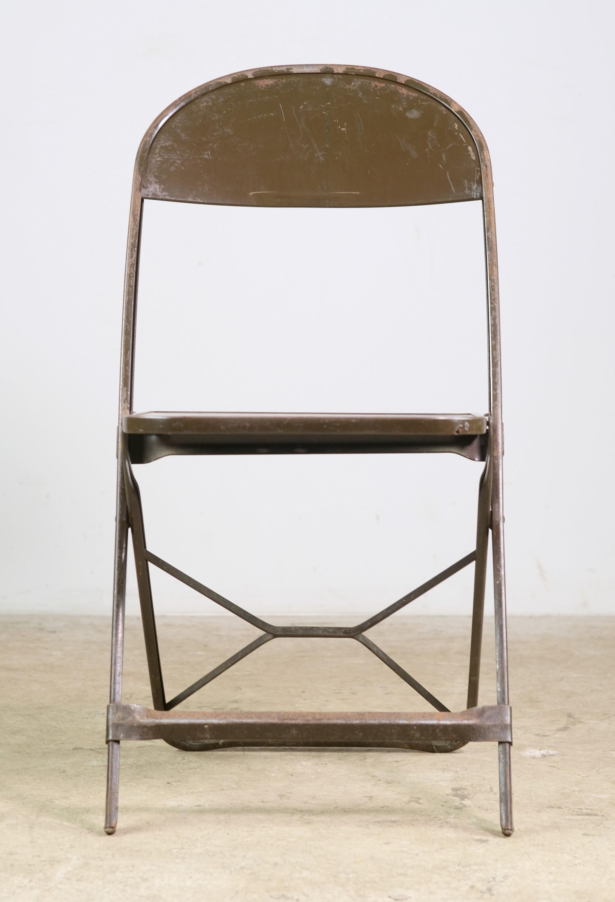 Early to Mid-20th Century steel industrial folding chairs. Each chair features a perforated star deign on its seat. Minor chipping in the original brown finish. Small quantity available at time of posting. Priced each. Please inquire. Please note,