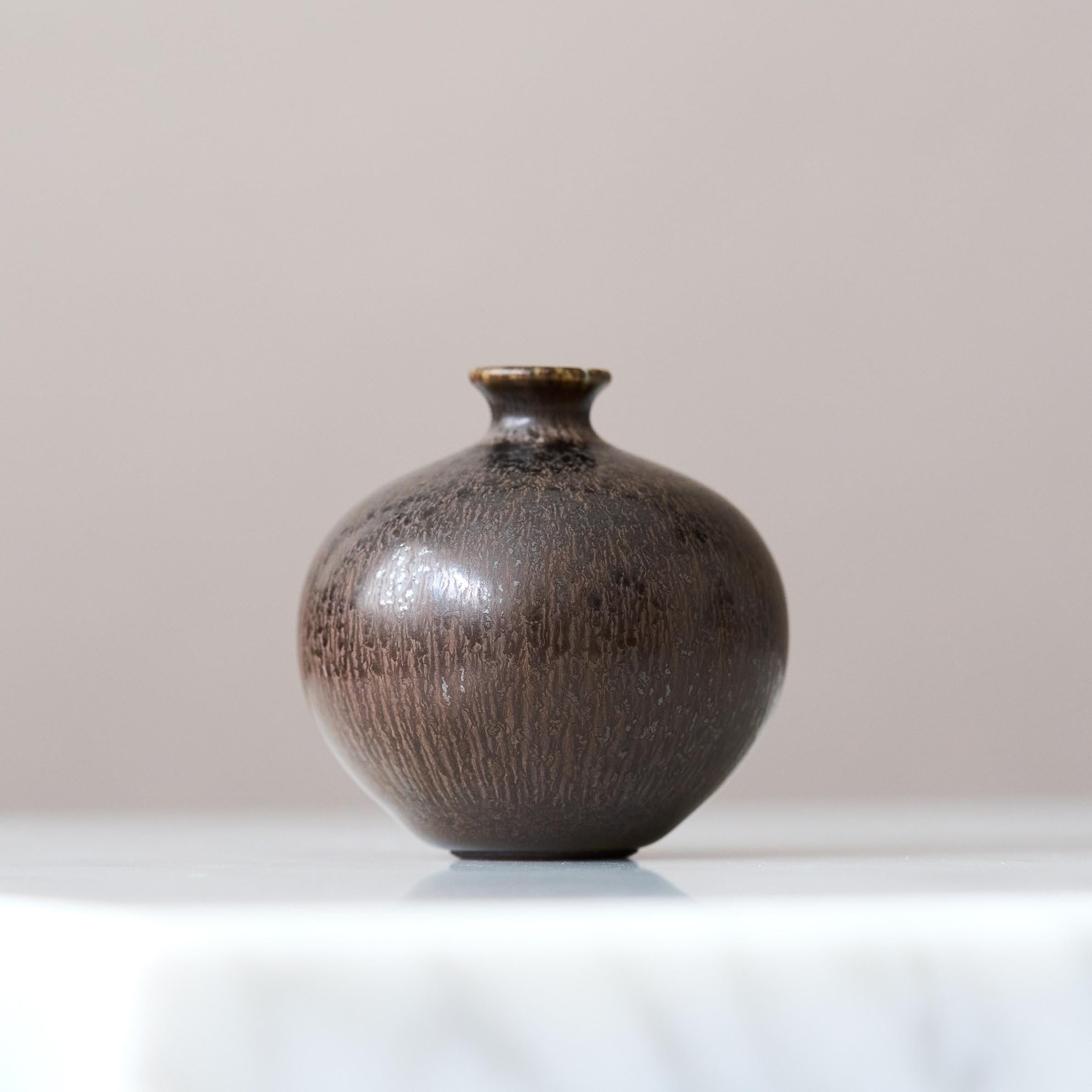 Eine schöne Miniaturvase aus Steinzeug mit erstaunlicher dunkelbrauner Hasenfellglasur.
Hergestellt von Berndt Friberg, einem Meister des Werfens, im Atelier des Künstlers in Gustavsberg, Schweden, 1954.

Toller Zustand. 
Eingeschnittene Signatur