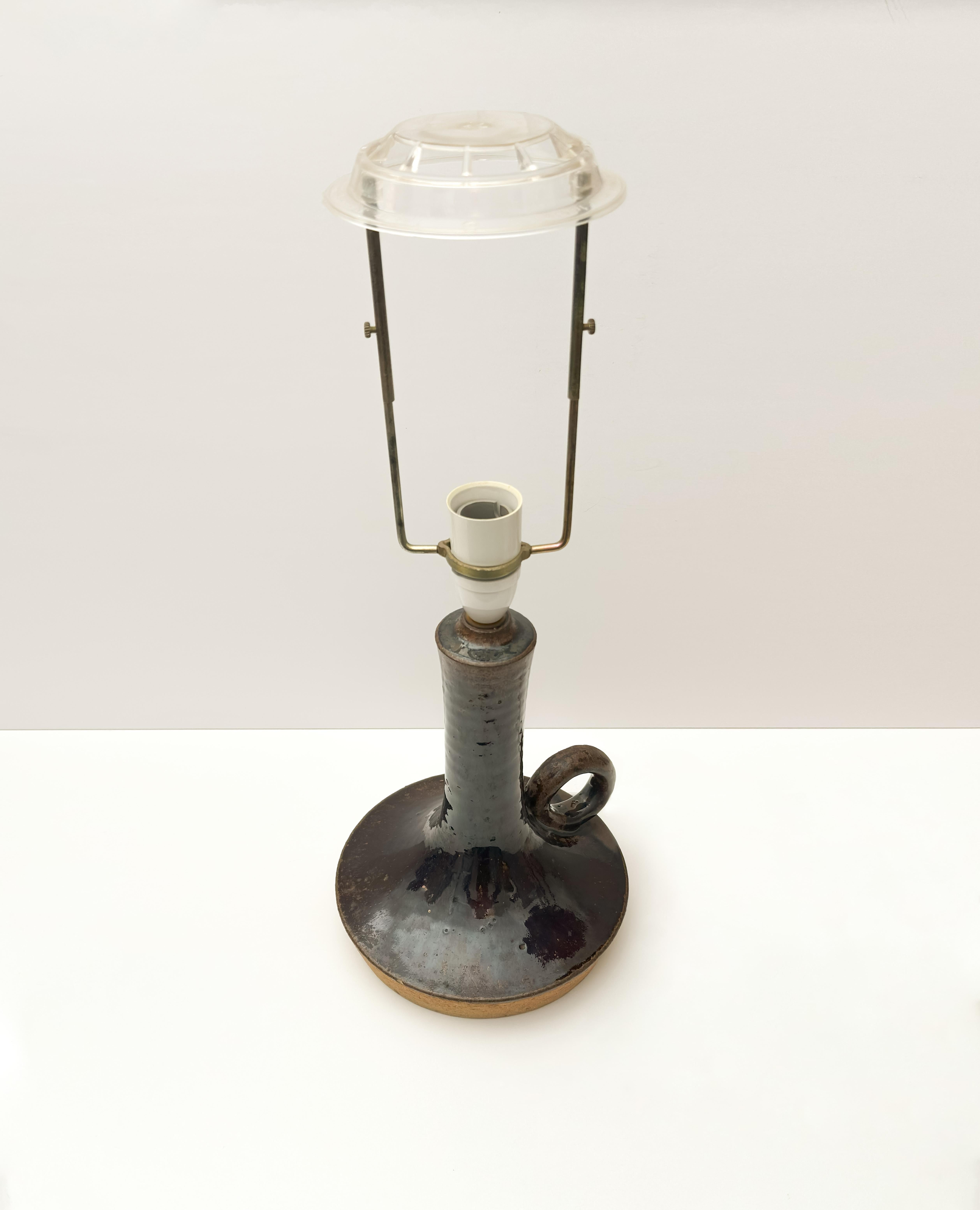 Cette lampe de table en grès brutaliste a été conçue par Jette Hellerøe pour la société danoise Axella, dans les années 1970. Sa forme sculpturale - avec une large base circulaire, une tige allongée et un manche en anneau minimaliste - réinterprète