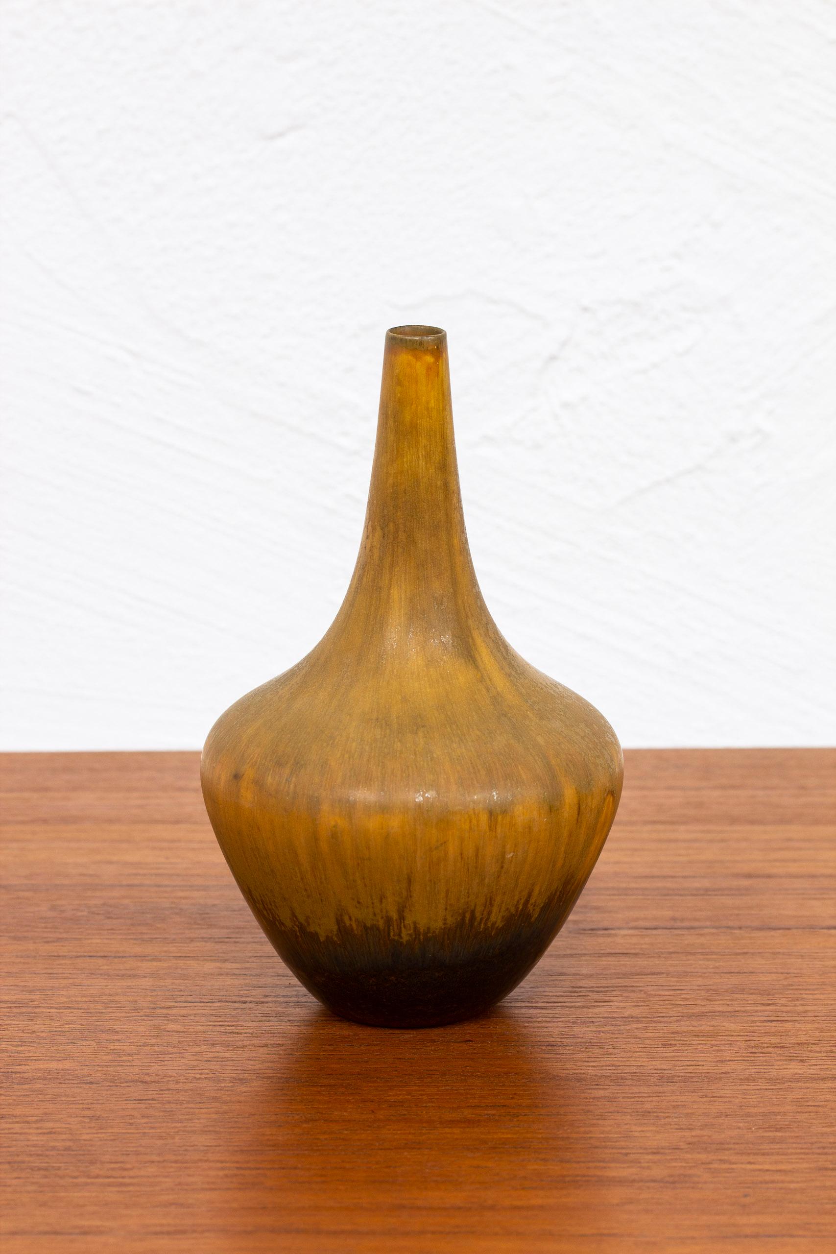 Stoneware vase designed by Gunnar Nylund. Hand made at Rörstrand in the 1940s. Glaze with burnt brown tones. Very good vintage condition with light wear and patina.

Dimensions: Ø. 14 H. 21 cm.
 

