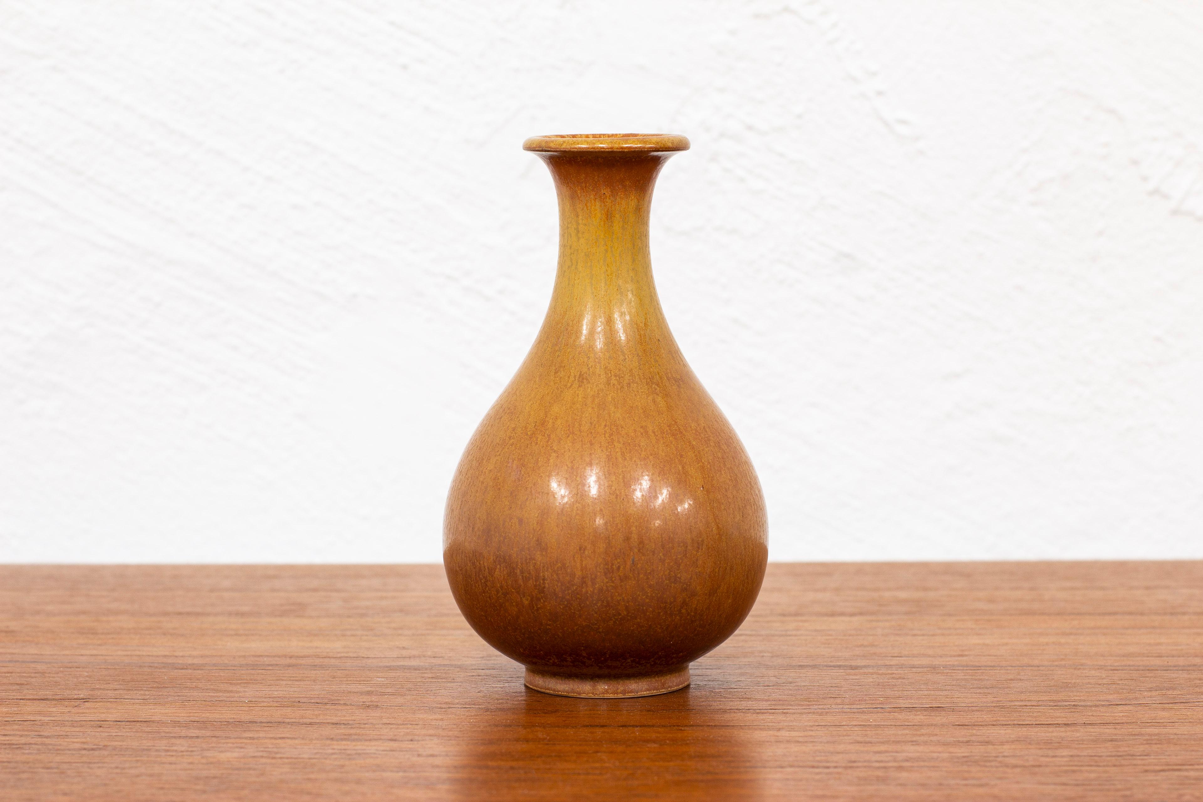 Stoneware vase designed by Gunnar Nylund. Hand made at Rörstrand in the 1940s. Glaze with burnt brown tones. Very good vintage condition with light wear and patina.

Dimensions: H. 14.5 Ø. 9 cm.

