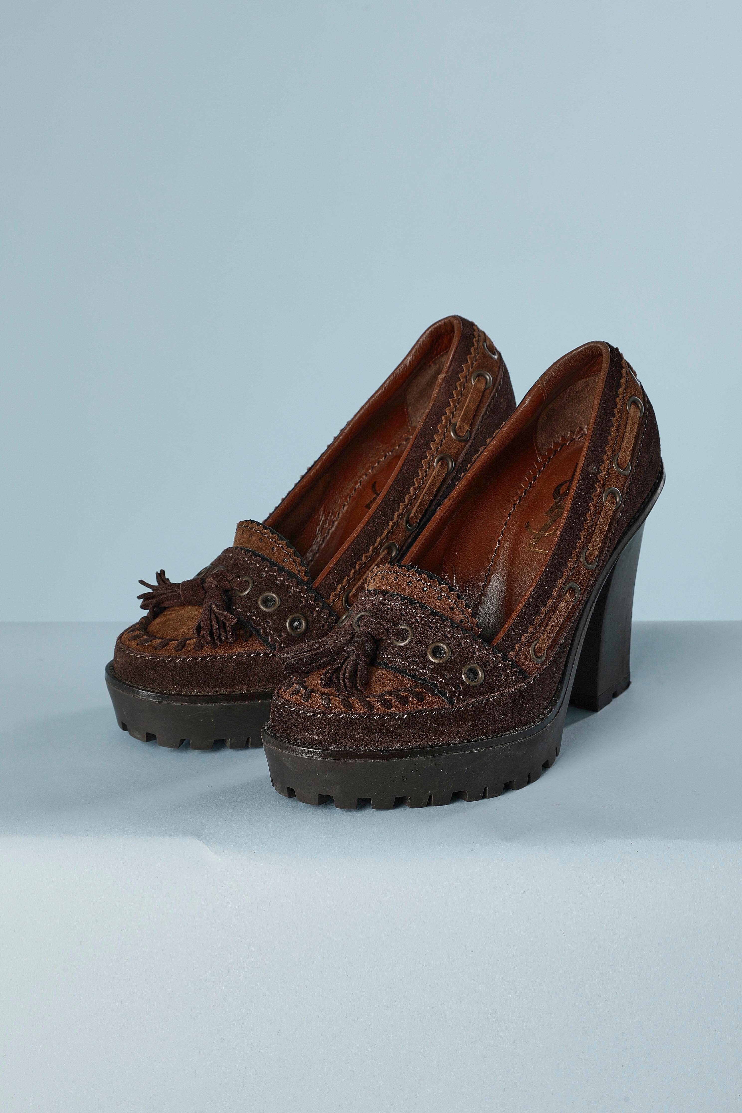 Brown suede heeled loafer with platform. Top-stitched, pompom and eyelet. 
Heel height = 10,5 cm
Platform height = 2,5 cm 
Shoe size: 36 ( It) 