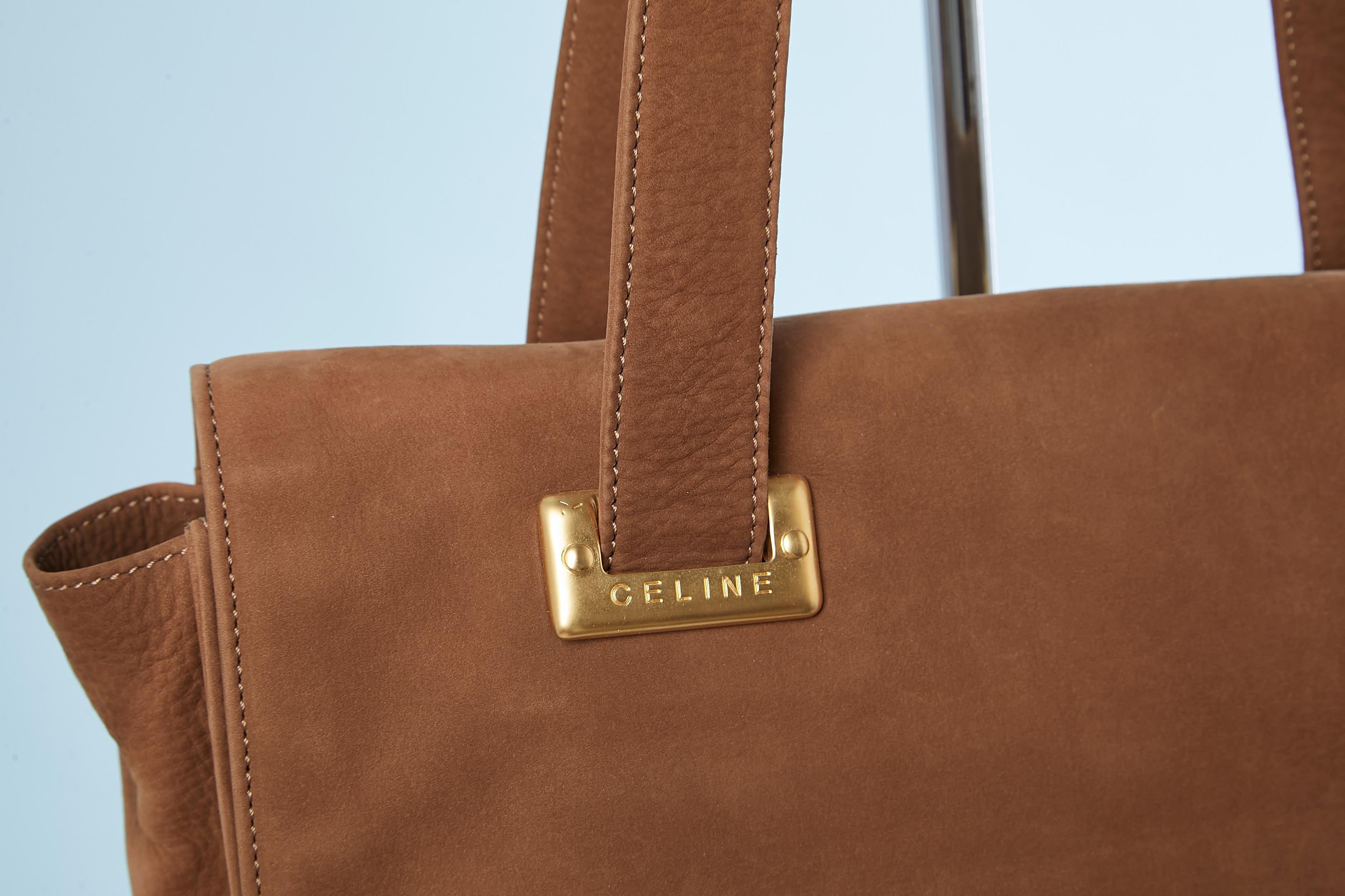 Brown suede shoulder bag with flap and gold metal hardware. Close with snap. 
Branded fabric lining. One flat pocket on the outside back. One pocket with zip inside and 2 without zip.
Size 31 cm X 23 X 7,5 cm 