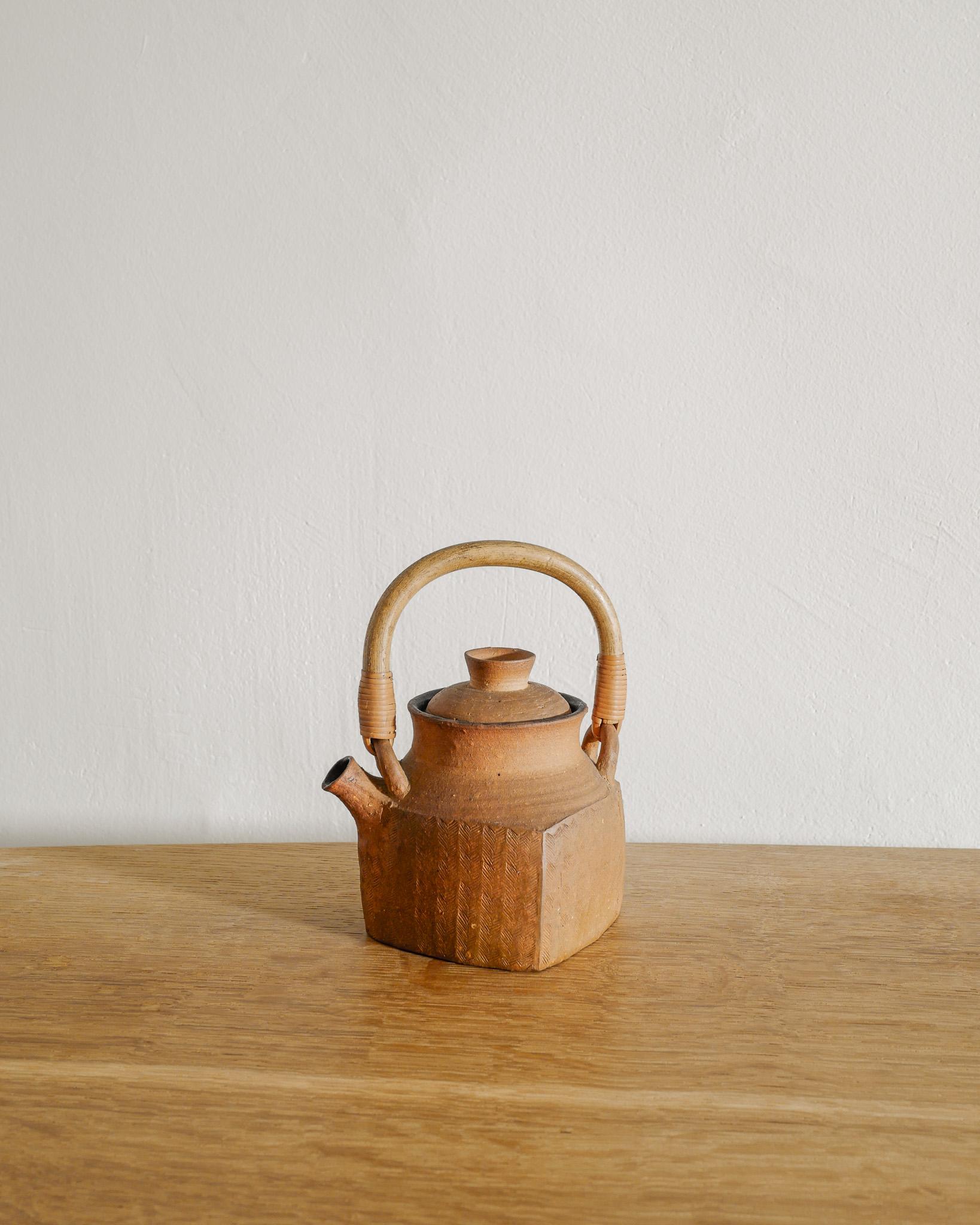 A very rare and unique decorative Swedish mid century stoneware tea pot pitcher with a bamboo and rattan handle by the Swedish ceramist Signe Persson-Melin produced in her own studio in Sweden 1963. In great original condition. Signed and dated at