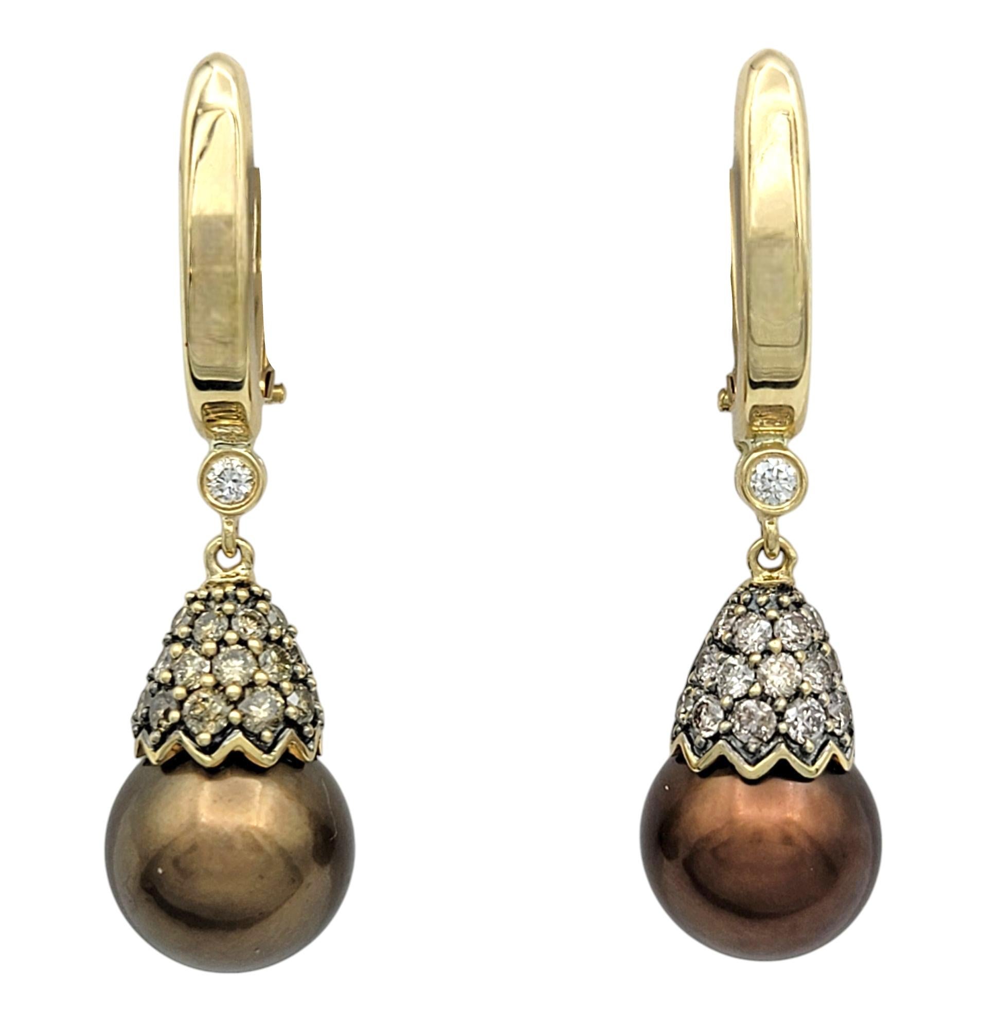 These exquisite drop earrings feature luminous chocolate brown Tahitian pearls with a warm overtone, exuding the utmost elegance. Their near-round shape and very good luster create a radiant glow, making them a captivating addition to any fine